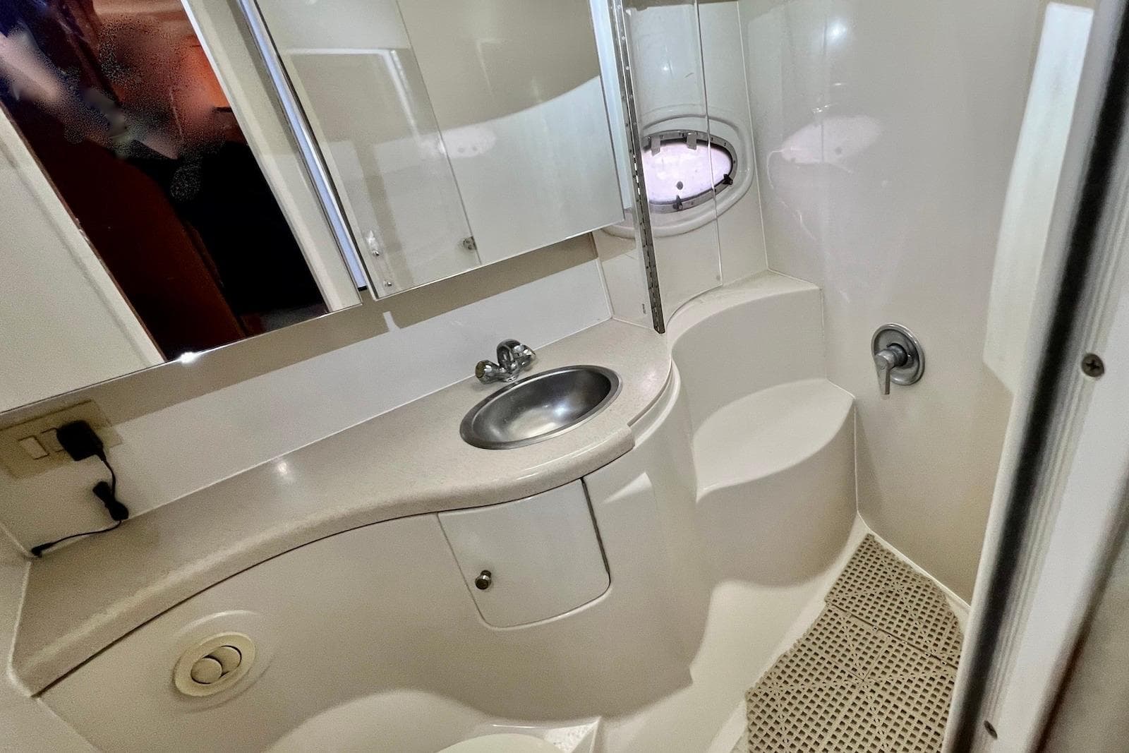 Bathroom interior of 2000 Regal Commodore 4160 yacht with sink and porthole.