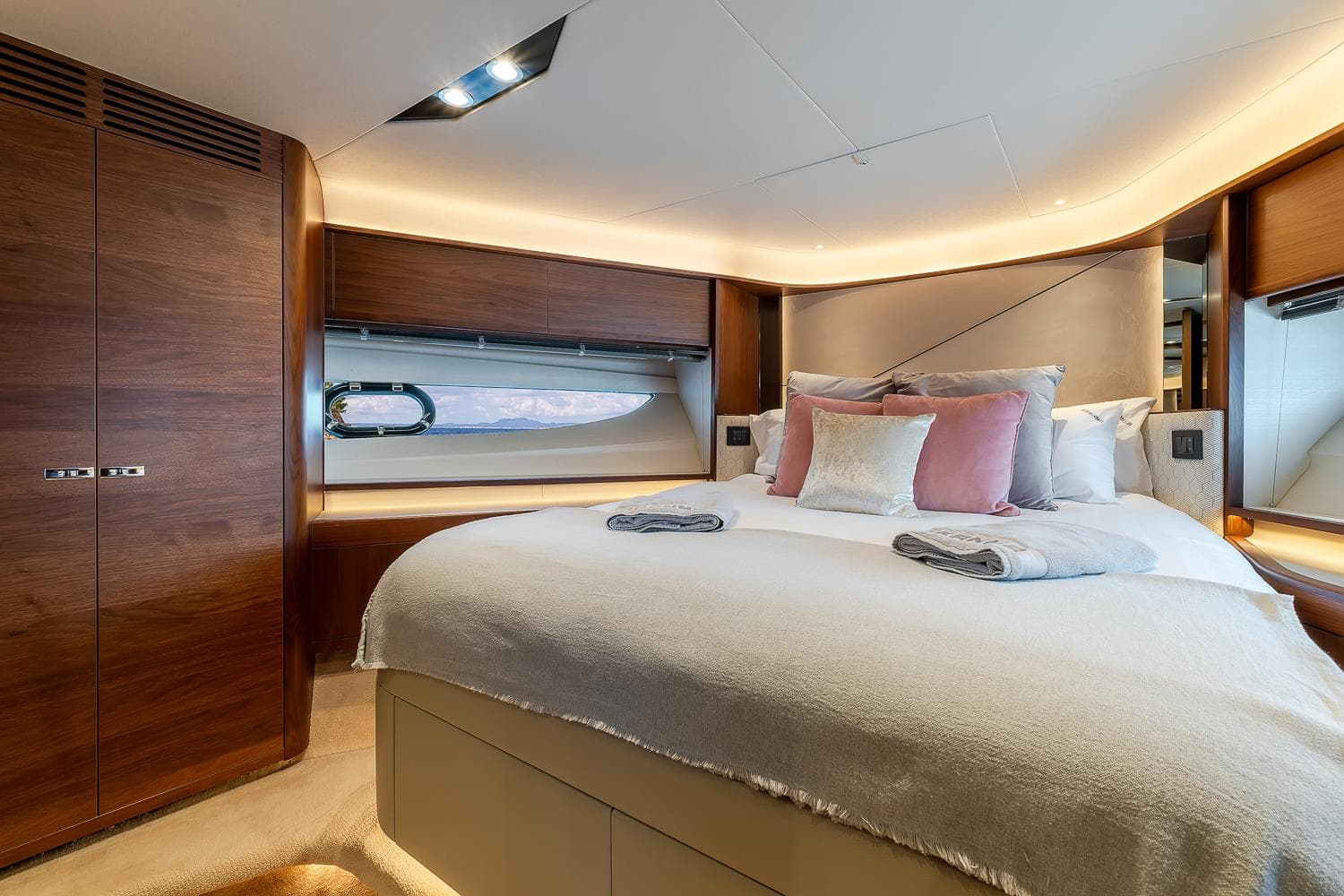 Luxurious bedroom interior of 2019 Princess S78 yacht with elegant wood finishes and plush bedding.