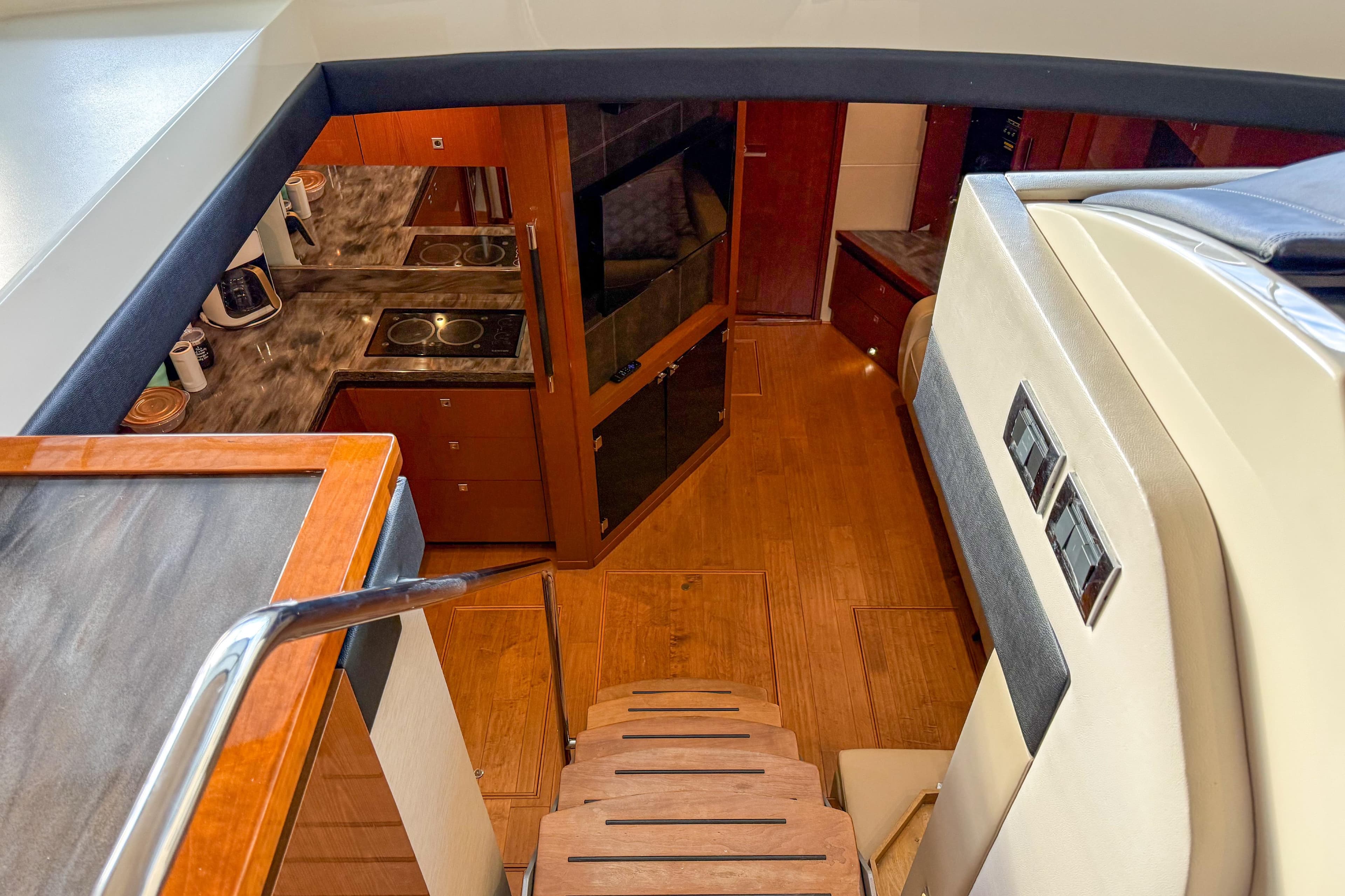 Interior view of 2016 Sea Ray Sundancer 510 yacht, featuring a modern kitchen and wooden flooring.