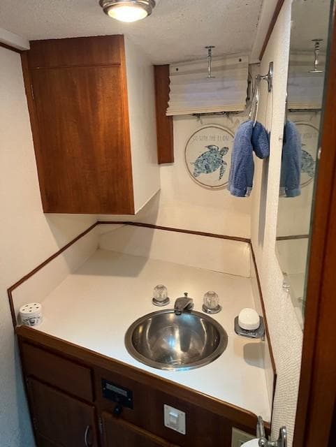 1972 DeFever 38 Passagemaker bathroom with sink, wooden cabinets, and nautical decor.