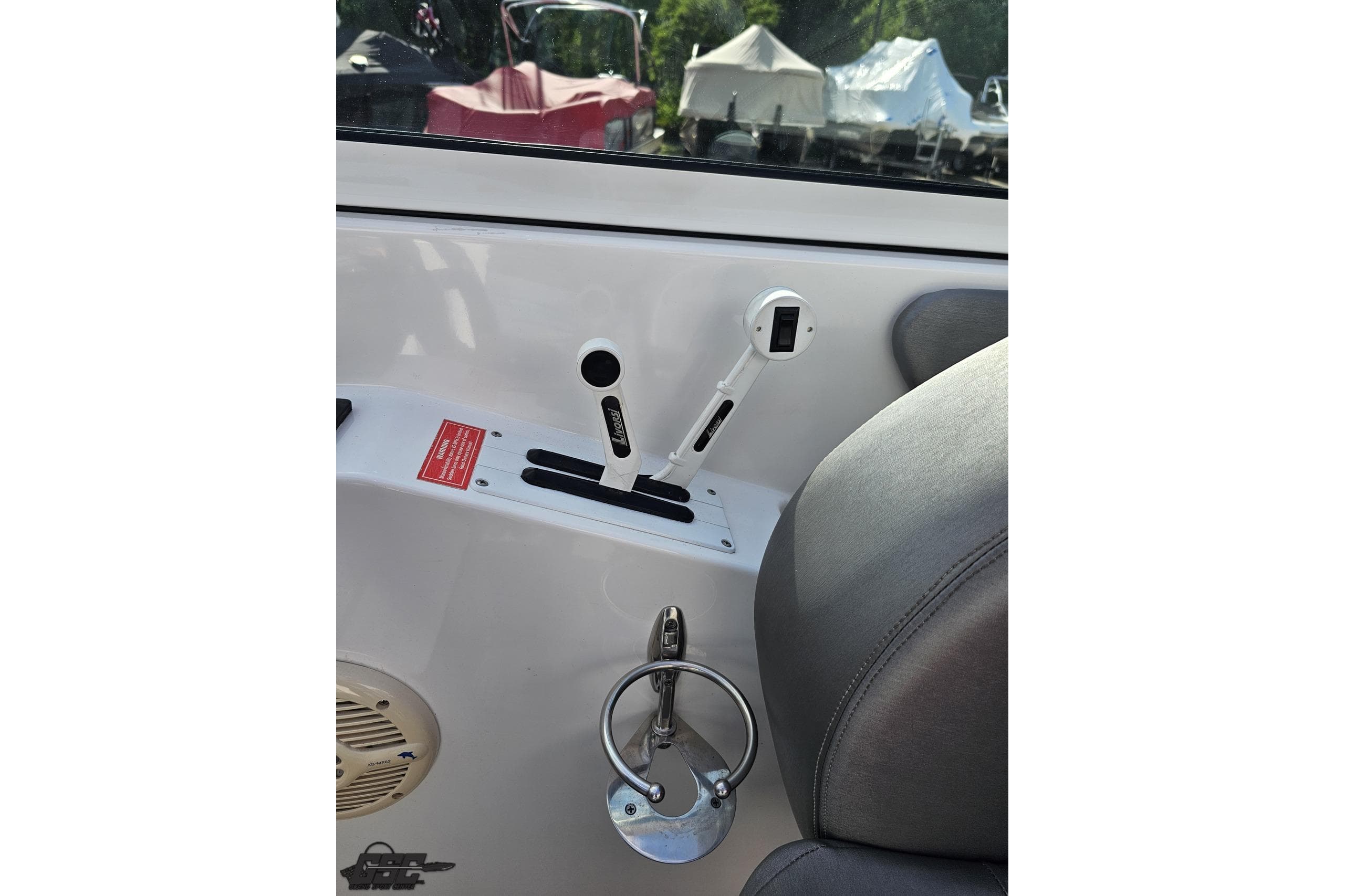 Interior controls of a 2006 Powerquest 240 Ultra LX boat, featuring throttle and cup holder.