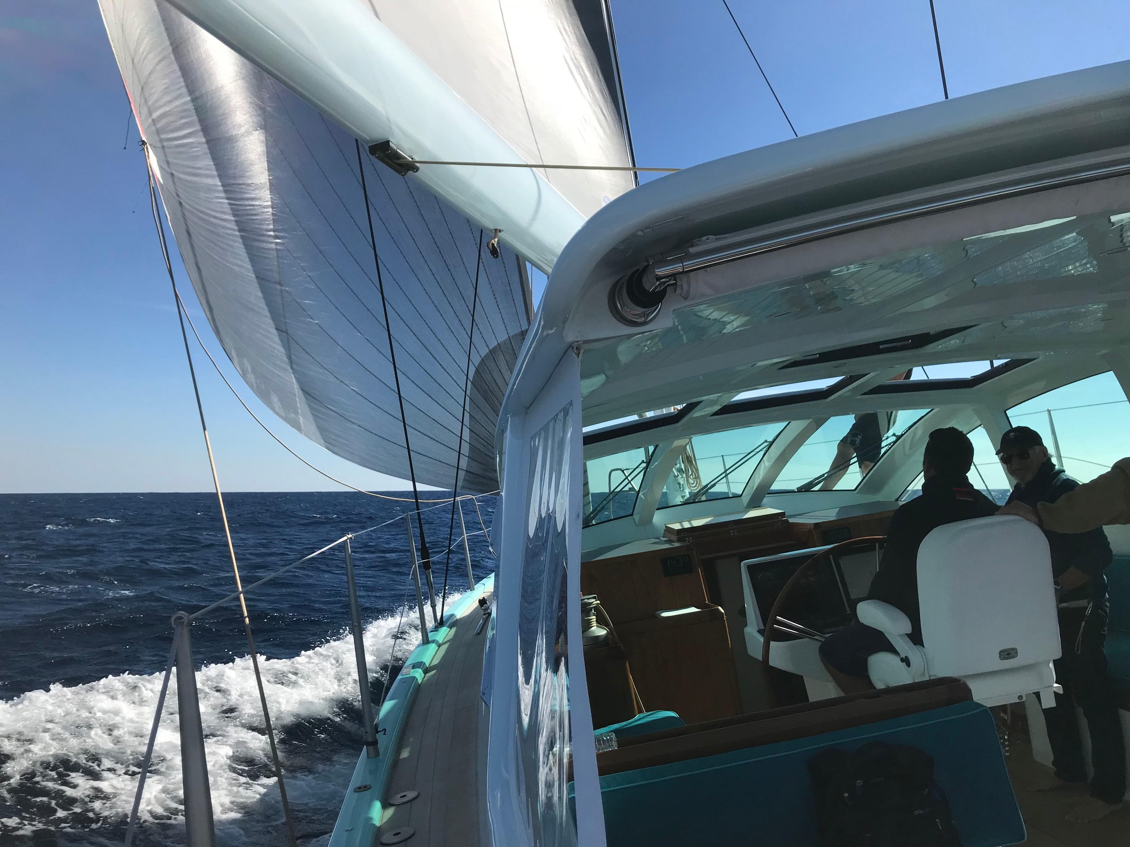 Sailing on a 2025 Surfari 50 yacht, gliding through the ocean under clear skies.