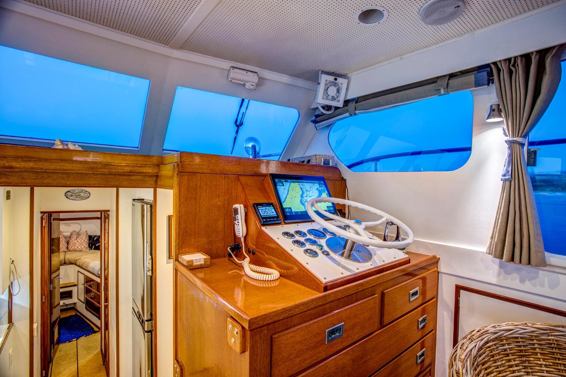 1964 Huckins Out Islander 56 yacht interior with wooden helm and navigation equipment.