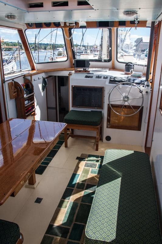 Interior of 1996 Custom Bolger PH Shoal-draft Ketch with helm, seating, and table.