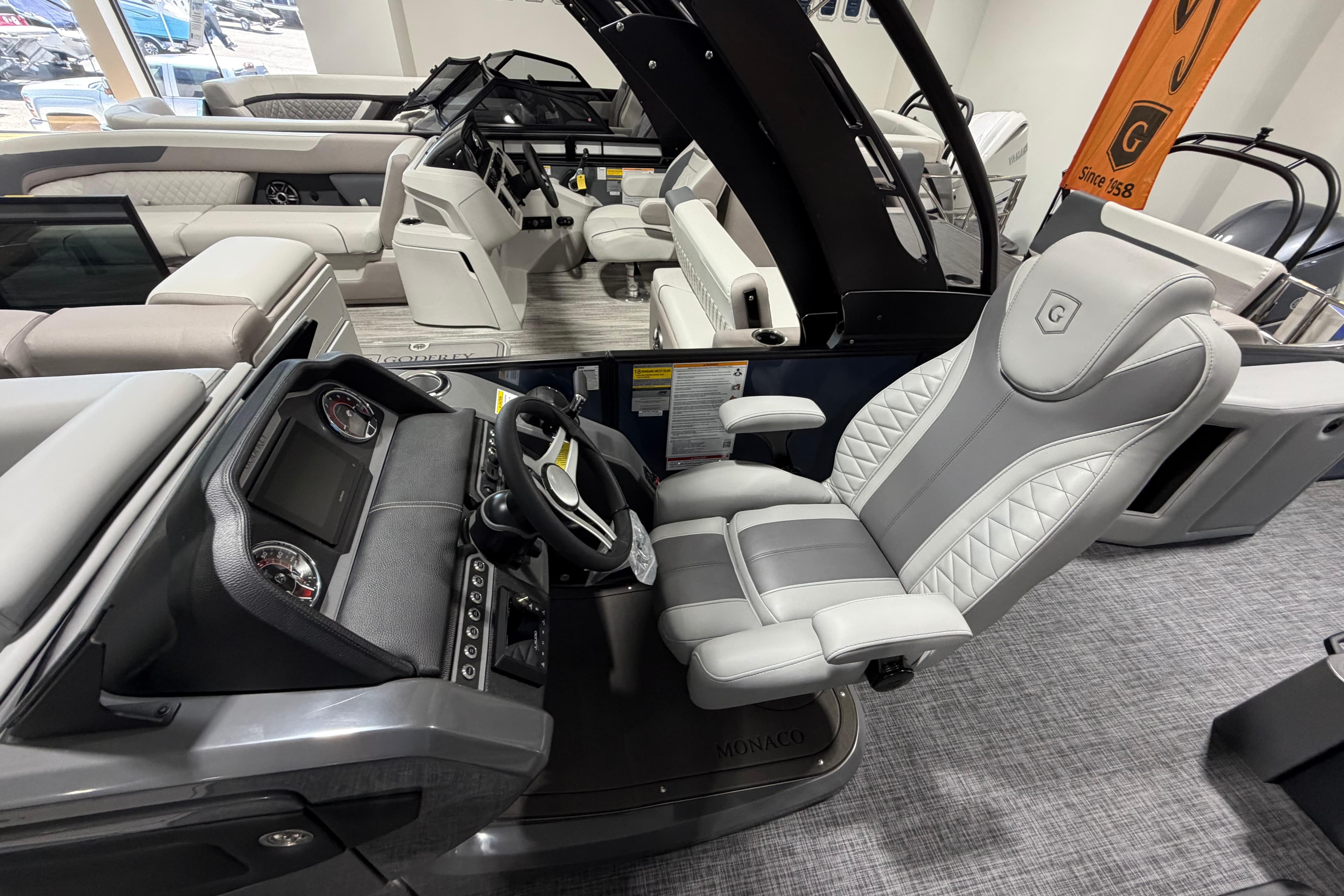 Luxurious interior of 2026 Godfrey Monaco 255 MTF pontoon boat with plush seating and modern dashboard.