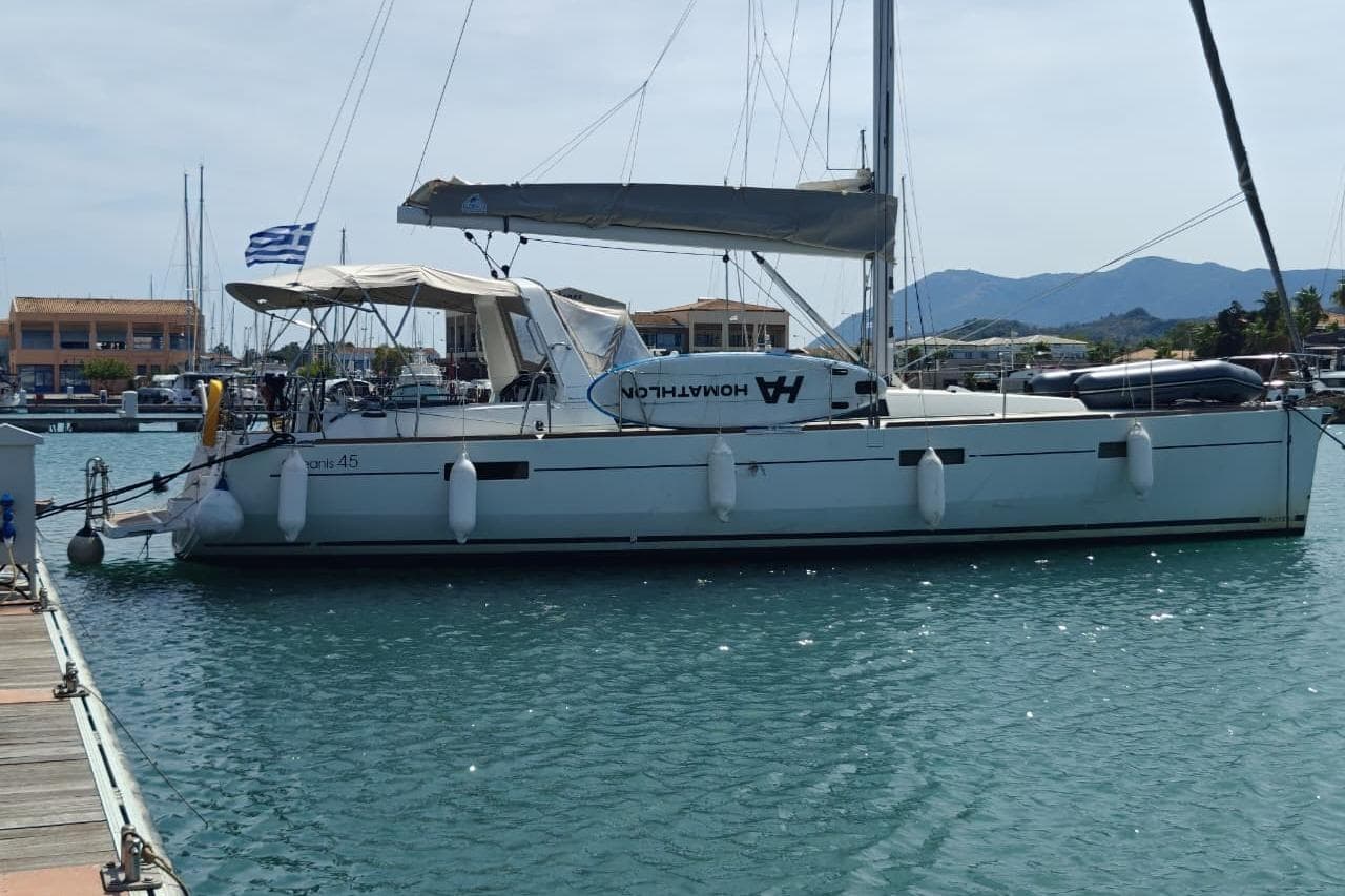 2016 Beneteau Oceanis 45 sailboat docked in marina with Greek flag.