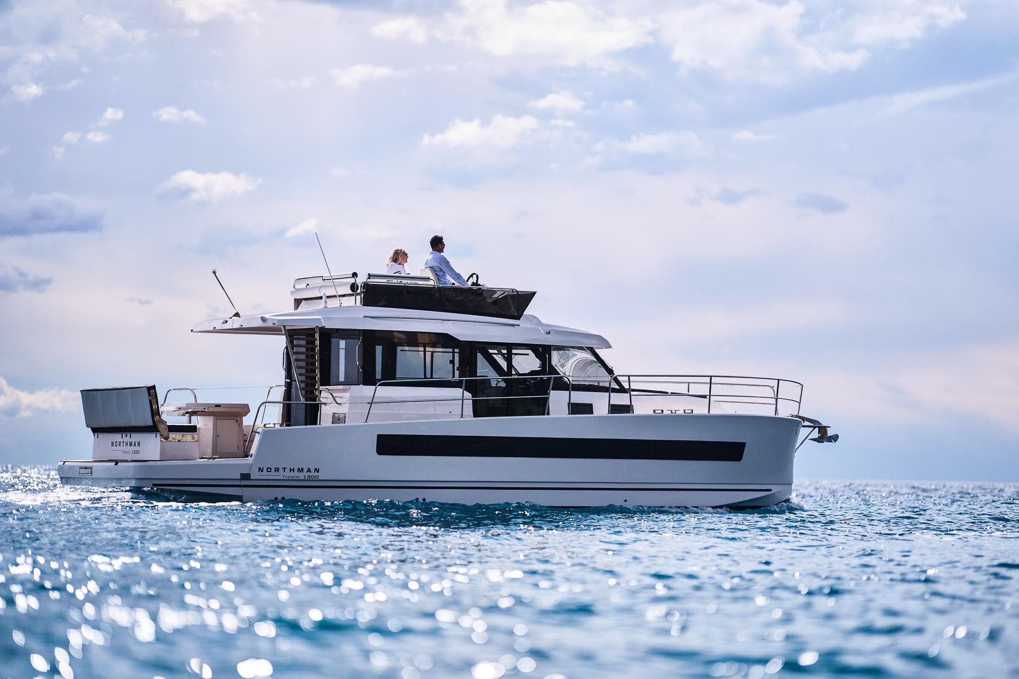 2025 Northman 1300 yacht cruising on open water under a partly cloudy sky.