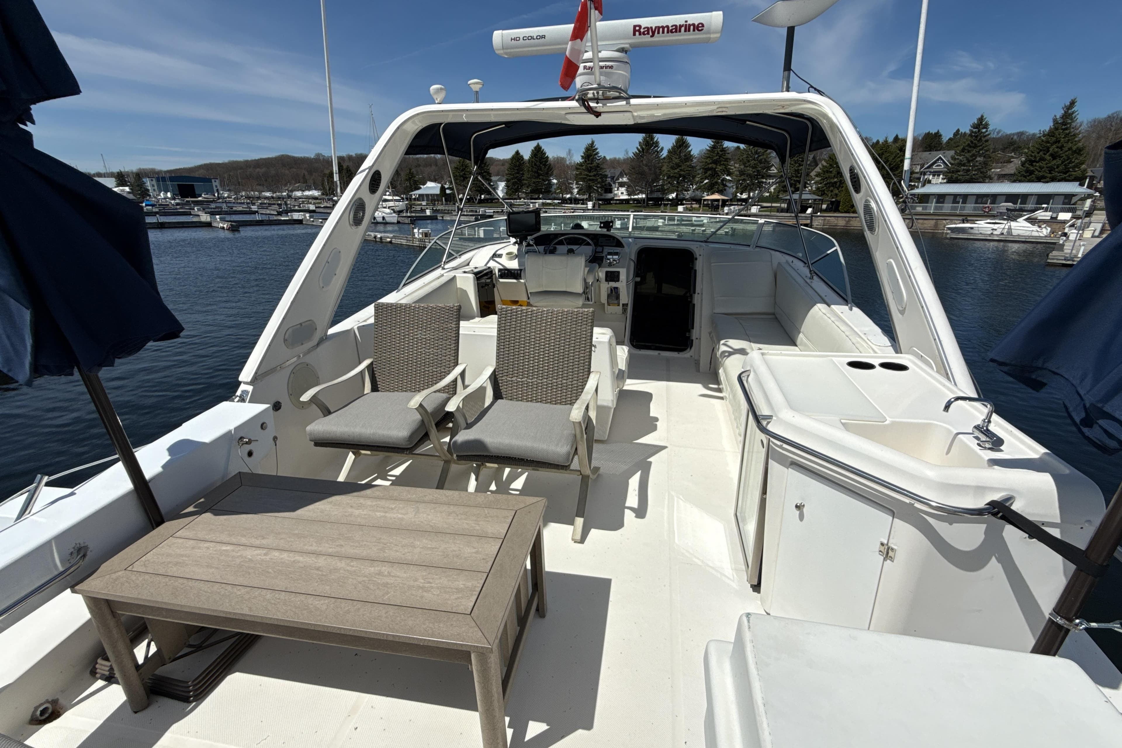 1997 Bayliner 4788 Pilot House Motoryacht deck with seating and table, docked at marina.