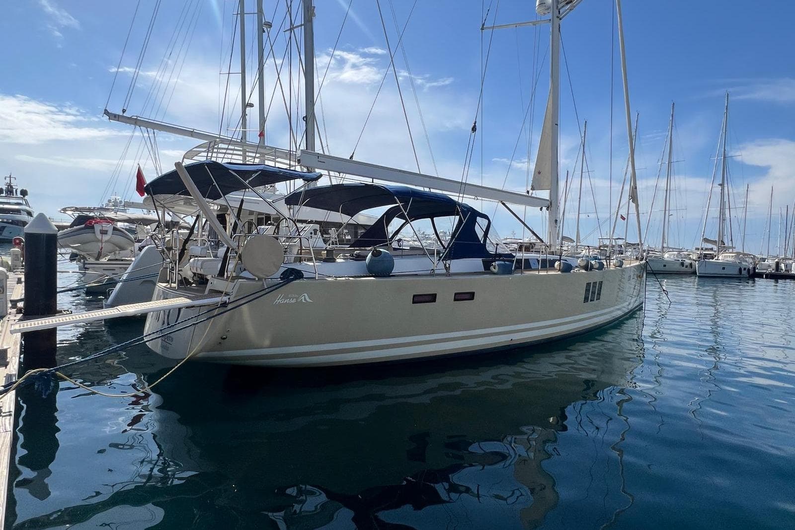 Sailing yacht Hanse 630 e, 2010 model, docked in a marina under a clear blue sky.
