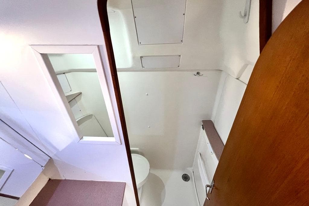Bathroom interior of 1999 Hunter Passage 420 yacht, featuring a compact design with a toilet and mirror.