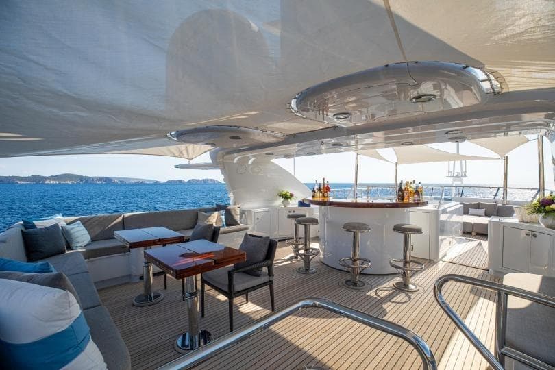 Luxurious 1998 Absolute Semi Displacement yacht deck with bar and seating, ocean view.