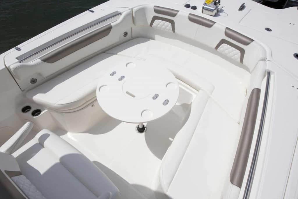2026 World Cat 295CC boat interior with white seating and round table.