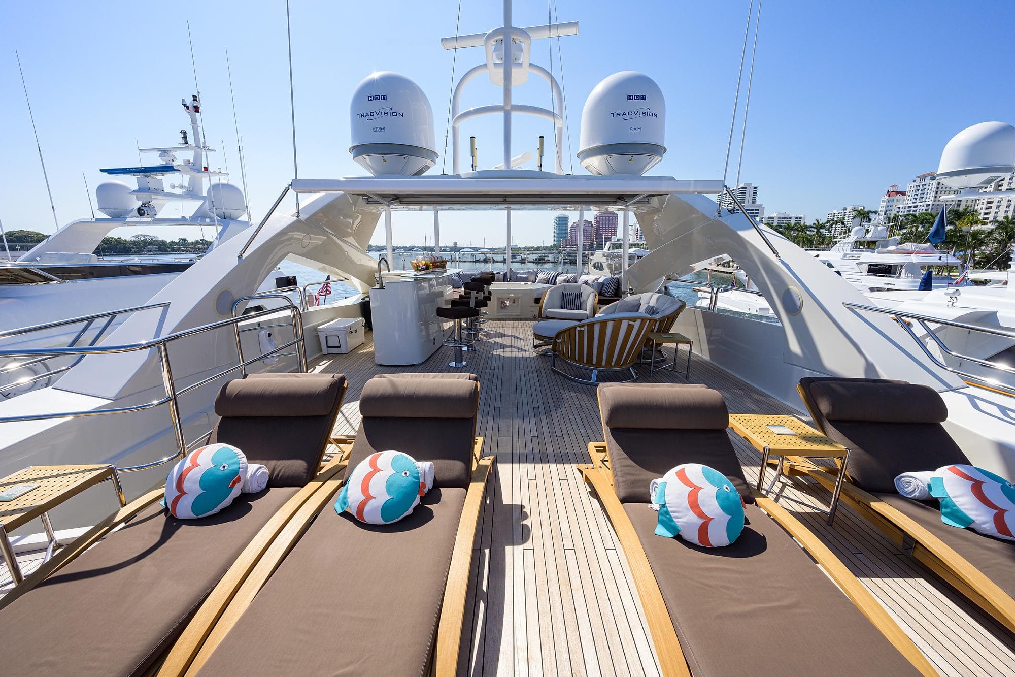 Luxurious 2009 Sunseeker Trideck yacht with sun loungers and scenic marina view.