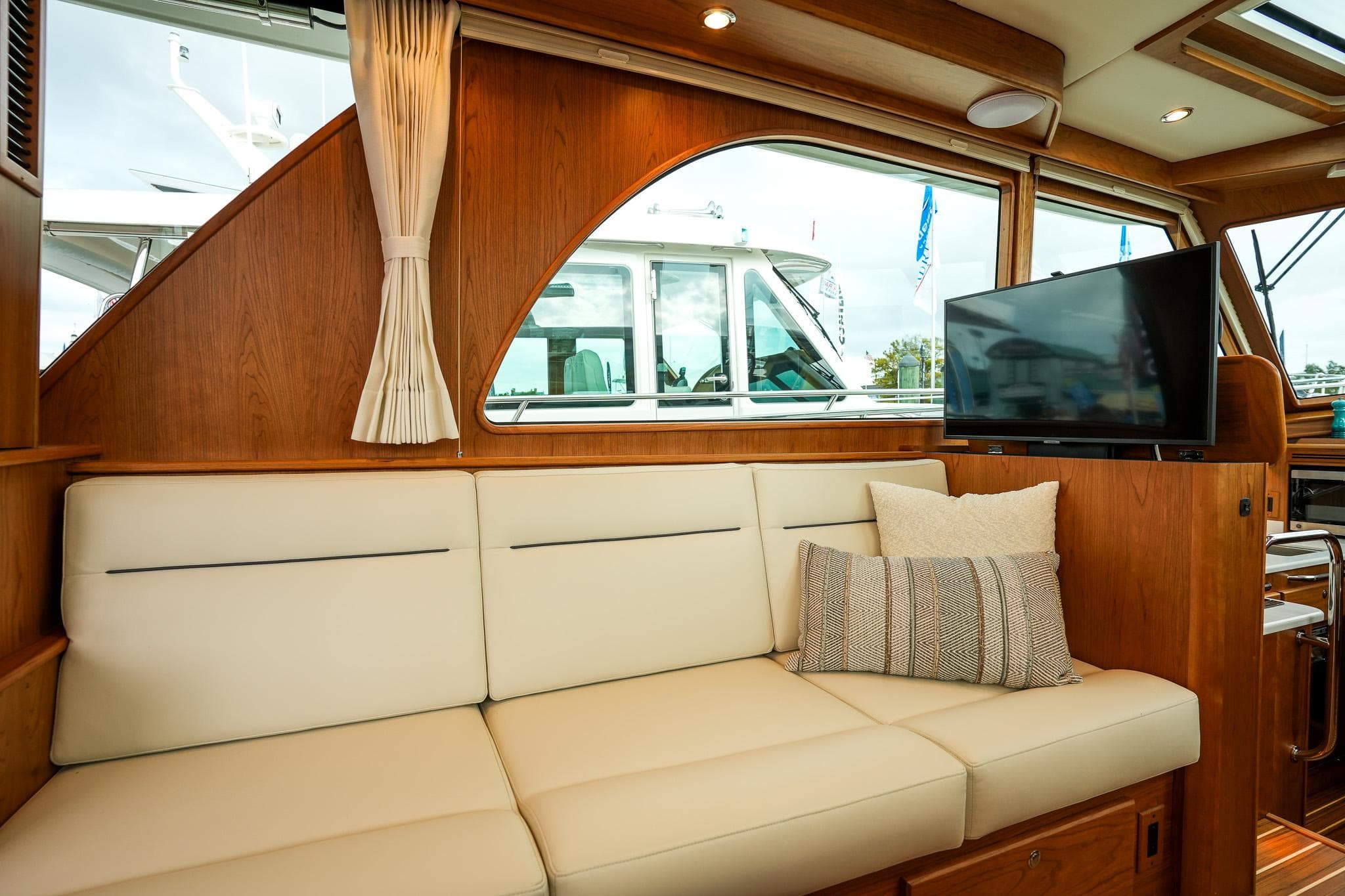 Interior of 2026 Sabre 45 Salon Express with cream sofa and TV.
