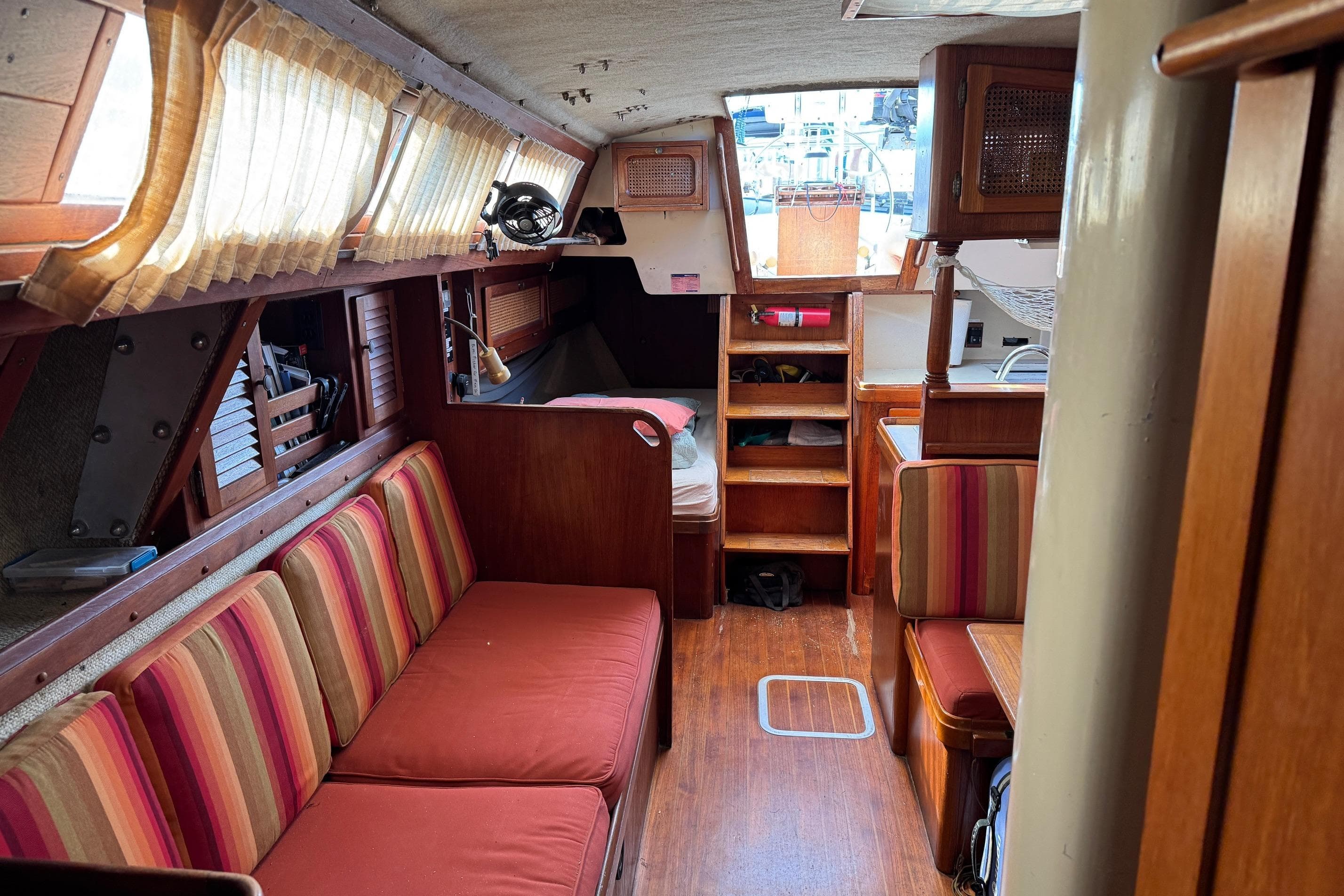 Interior of a 1981 S2 36 sailboat with cozy seating and wooden finishes.