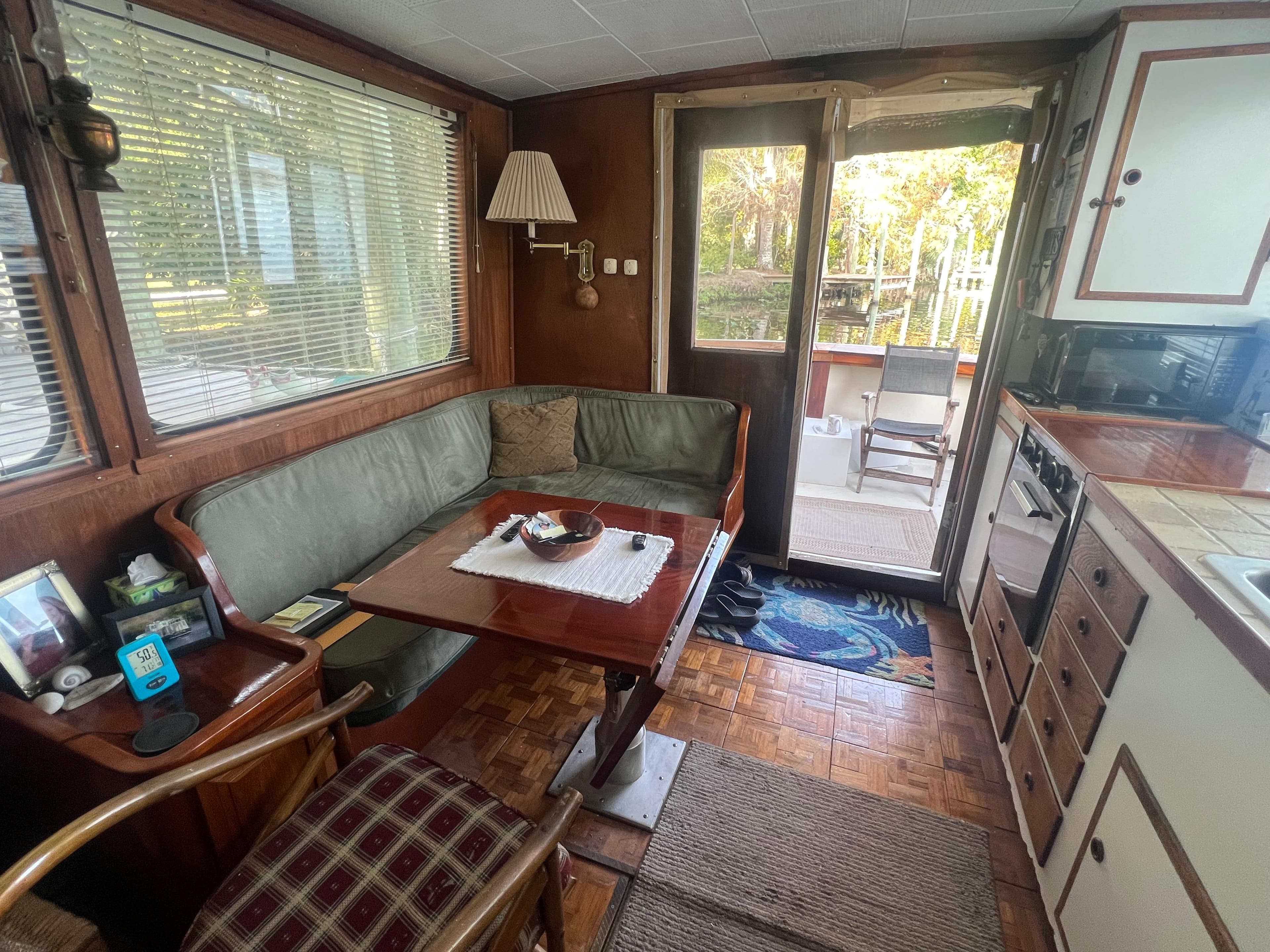 Cozy 1965 Romsdal Fjord boat interior with dining area and kitchenette.