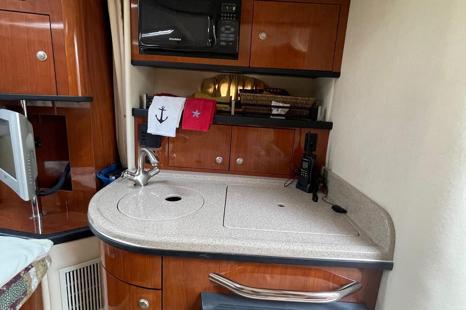 2007 Sea Ray 290 Sundancer interior with kitchenette, featuring wood cabinetry and modern appliances.