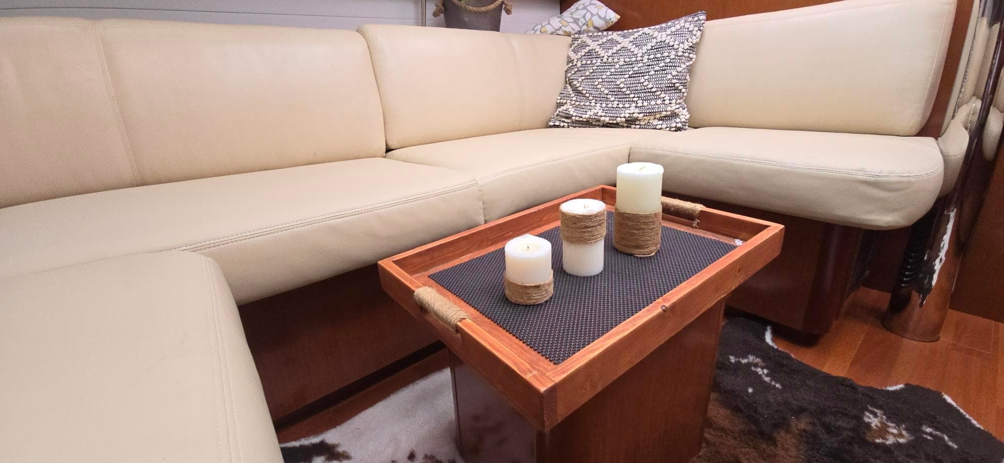 Luxurious interior of 2011 Beneteau Oceanis 46 yacht with beige seating and decorative candles.
