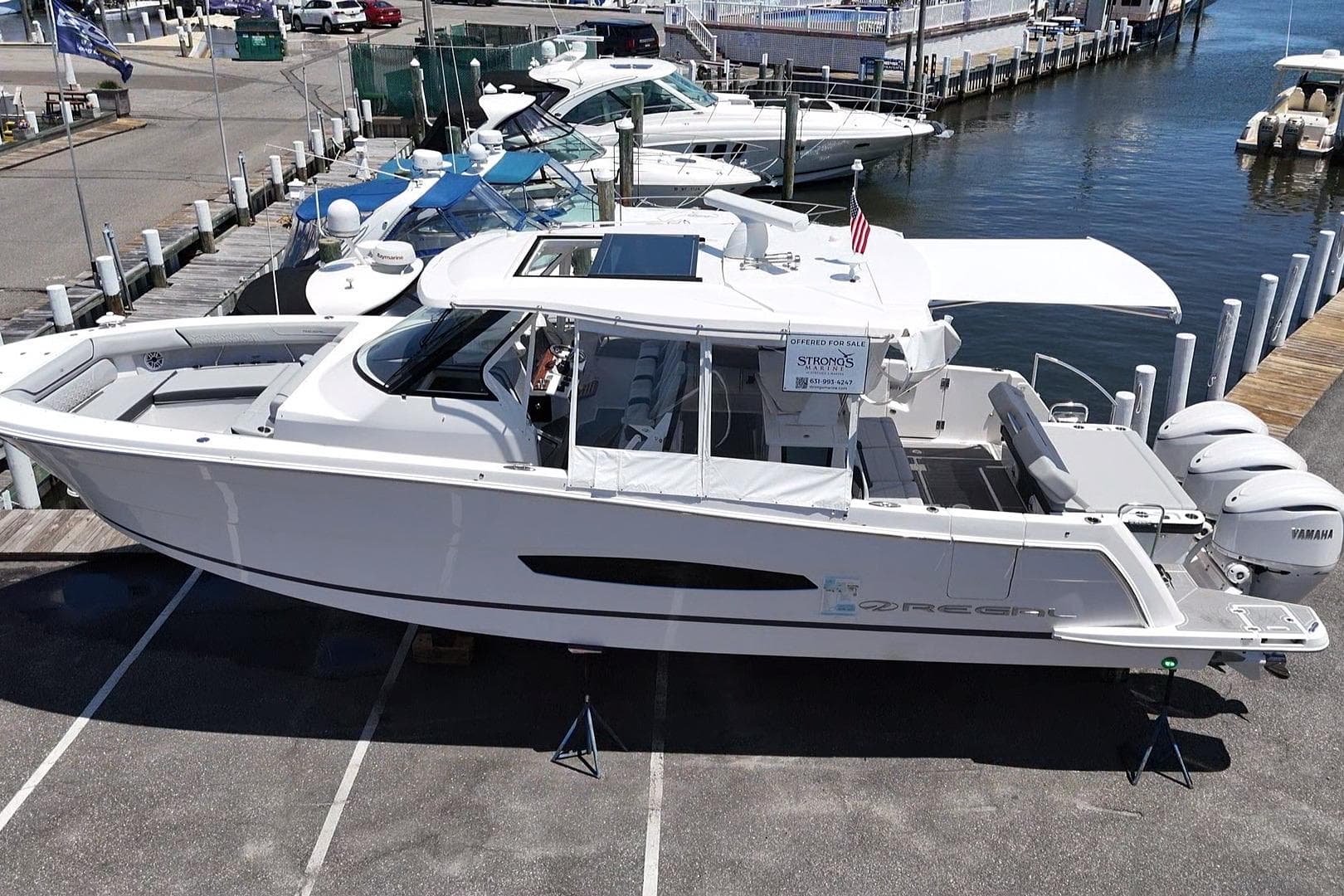 2026 Regal 38 SAV luxury boat docked at marina with Yamaha engines.