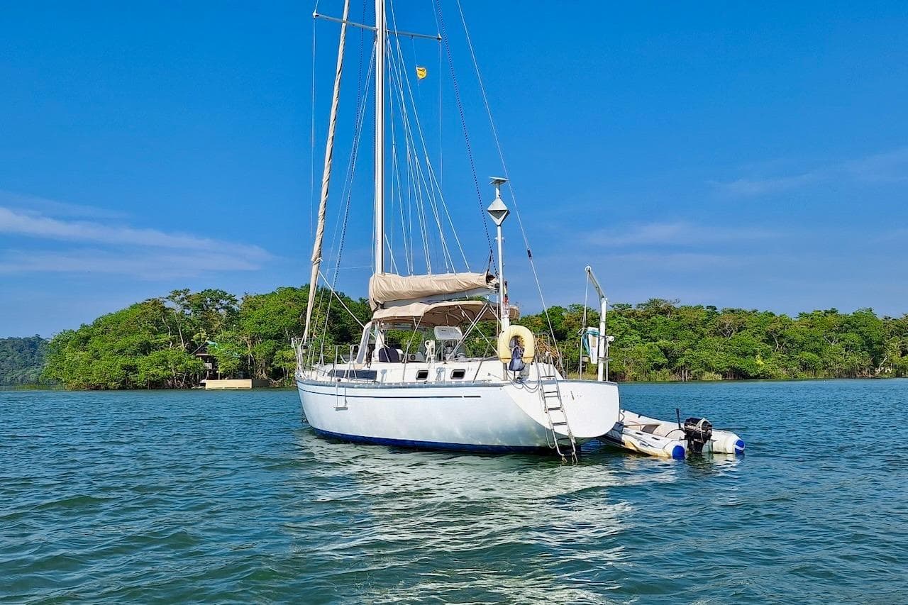 Sailboat Gulfstar Hirsch 45 CC, 1985 model, anchored near lush green island.