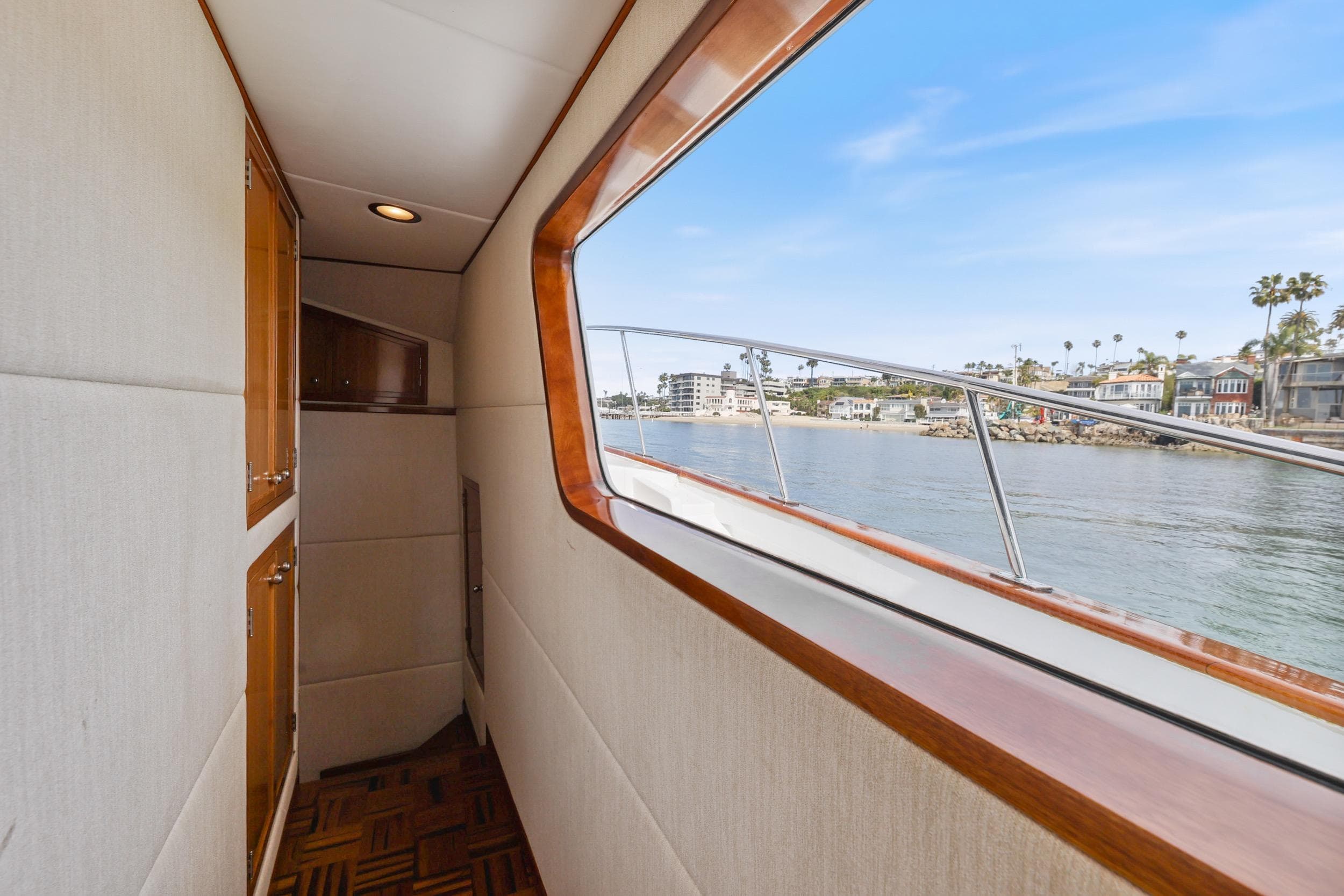 Interior view of 1970 Hargrave Yachtfisher, showcasing elegant wood finishes and scenic waterway.