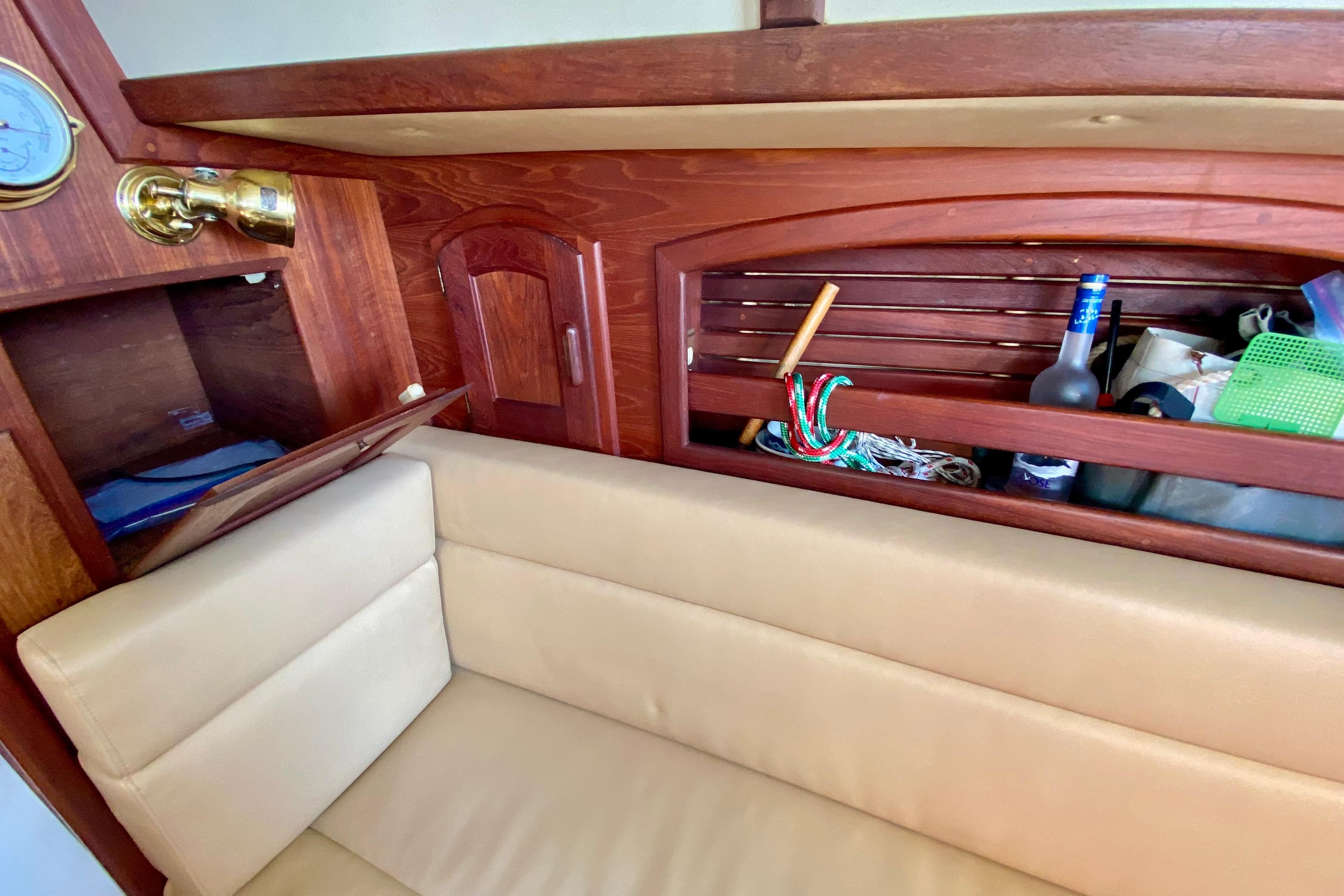 Interior of 1993 Pacific Seacraft 34 sailboat with beige seating and wooden storage.