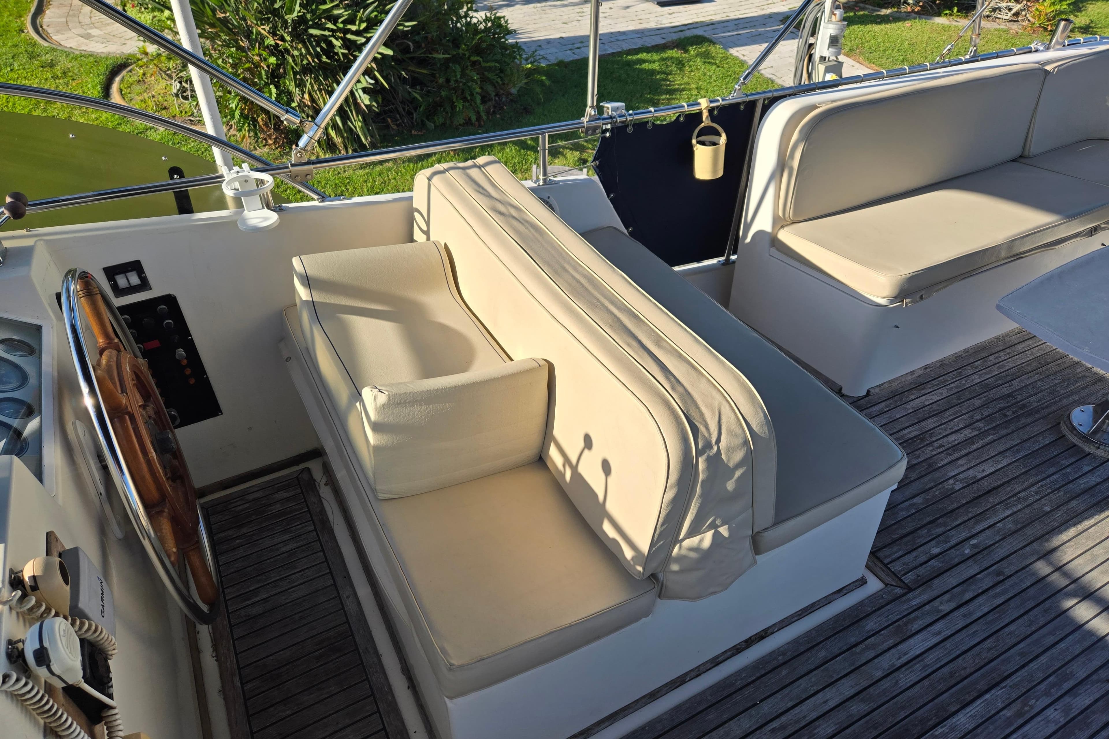 1992 Grand Banks 46 Classic yacht cockpit with cushioned seating and wooden steering wheel.