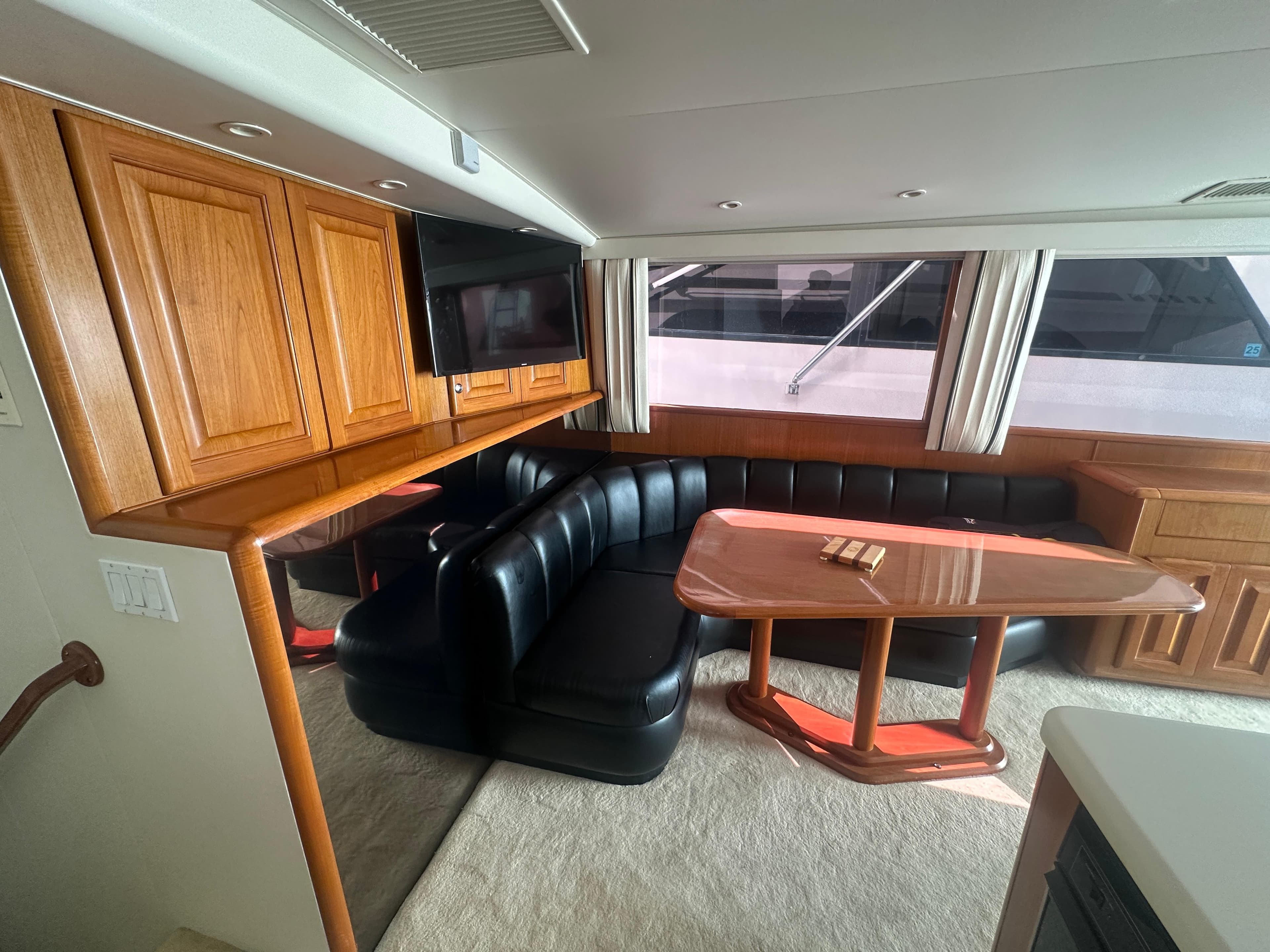 Luxurious interior of a 1998 Viking 53 Convertible yacht with leather seating and wooden cabinetry.