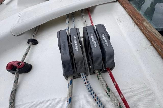 Deck of 1996 Beneteau 50 sailboat with rope clutches and lines.