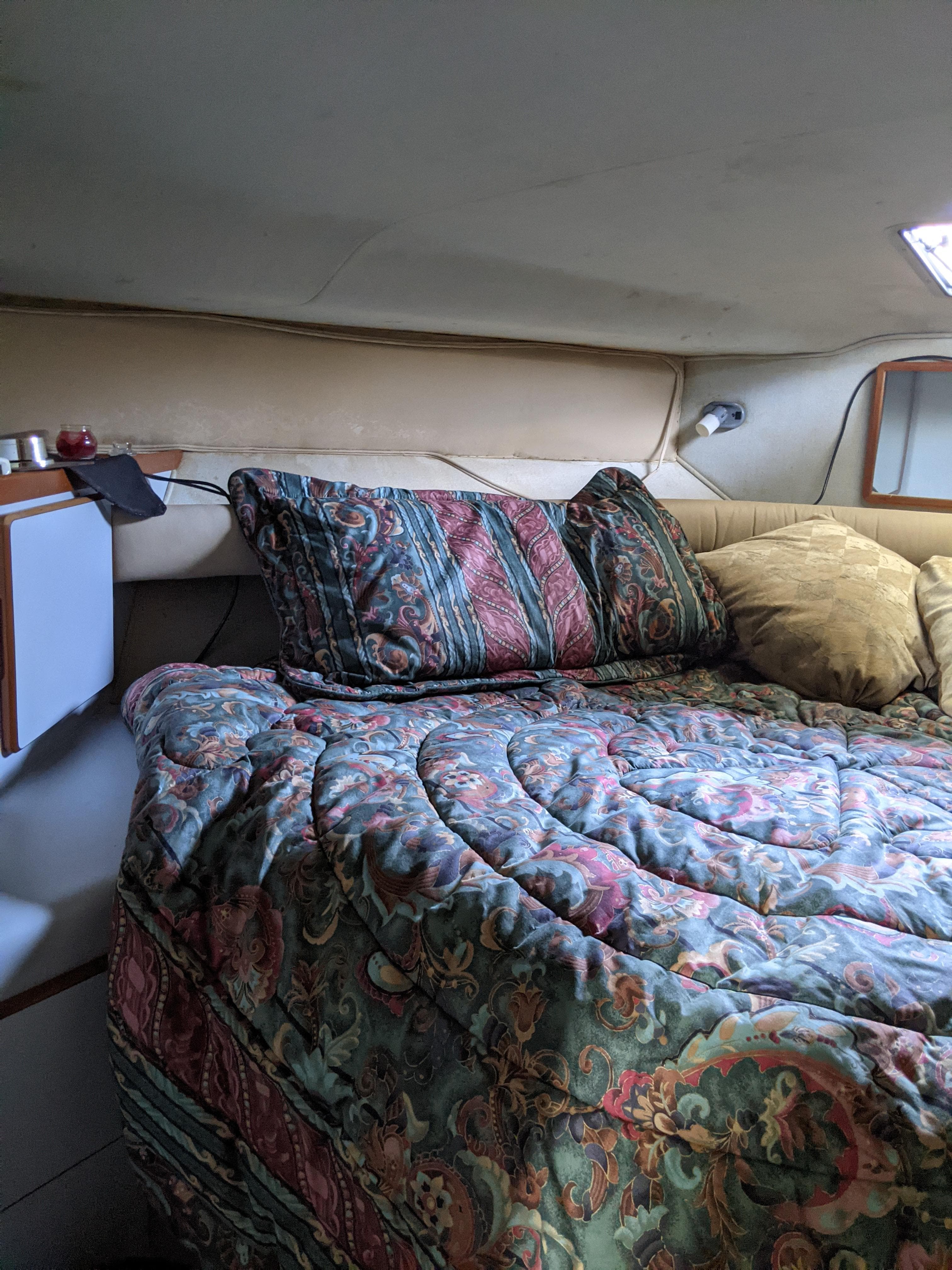 Cozy bedroom in 1989 Sea Ray 380 Aft Cabin yacht with patterned bedding.