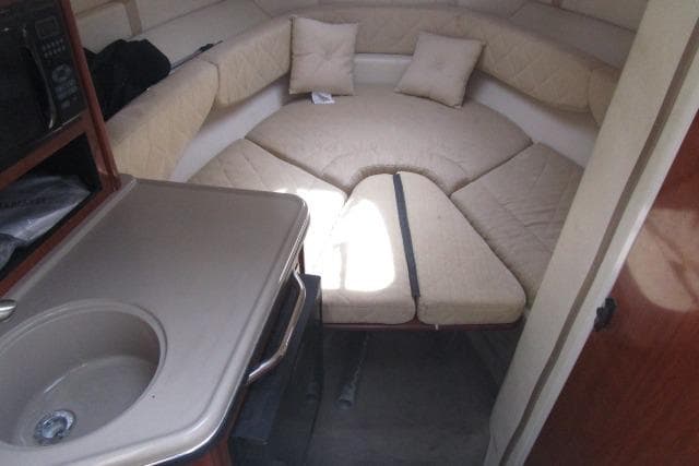 2006 Sea Ray 240 Sundancer cabin interior with seating, sink, and microwave.