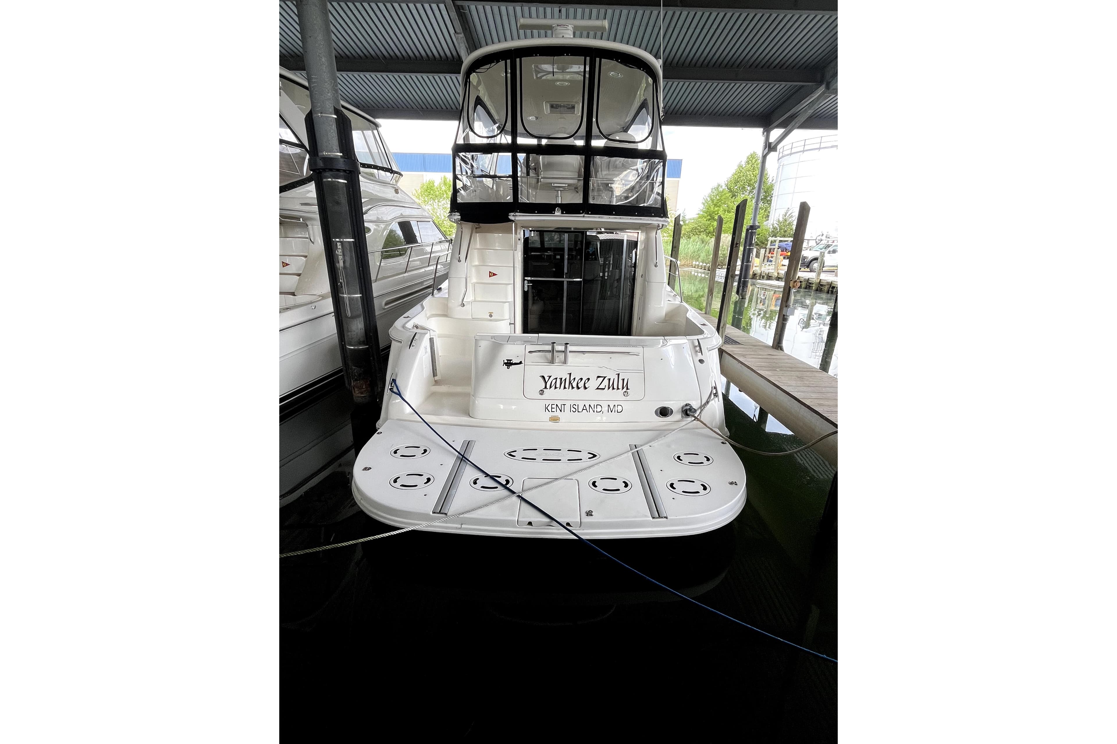 2003 Sea Ray 480 Sedan Bridge yacht docked in a marina, rear view.