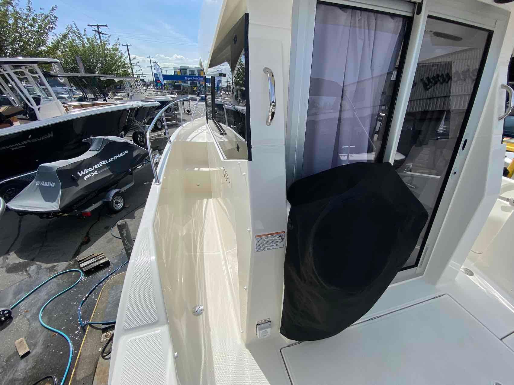 2024 Bayliner Trophy T25 Pilothouse boat exterior with side walkway and sliding door.