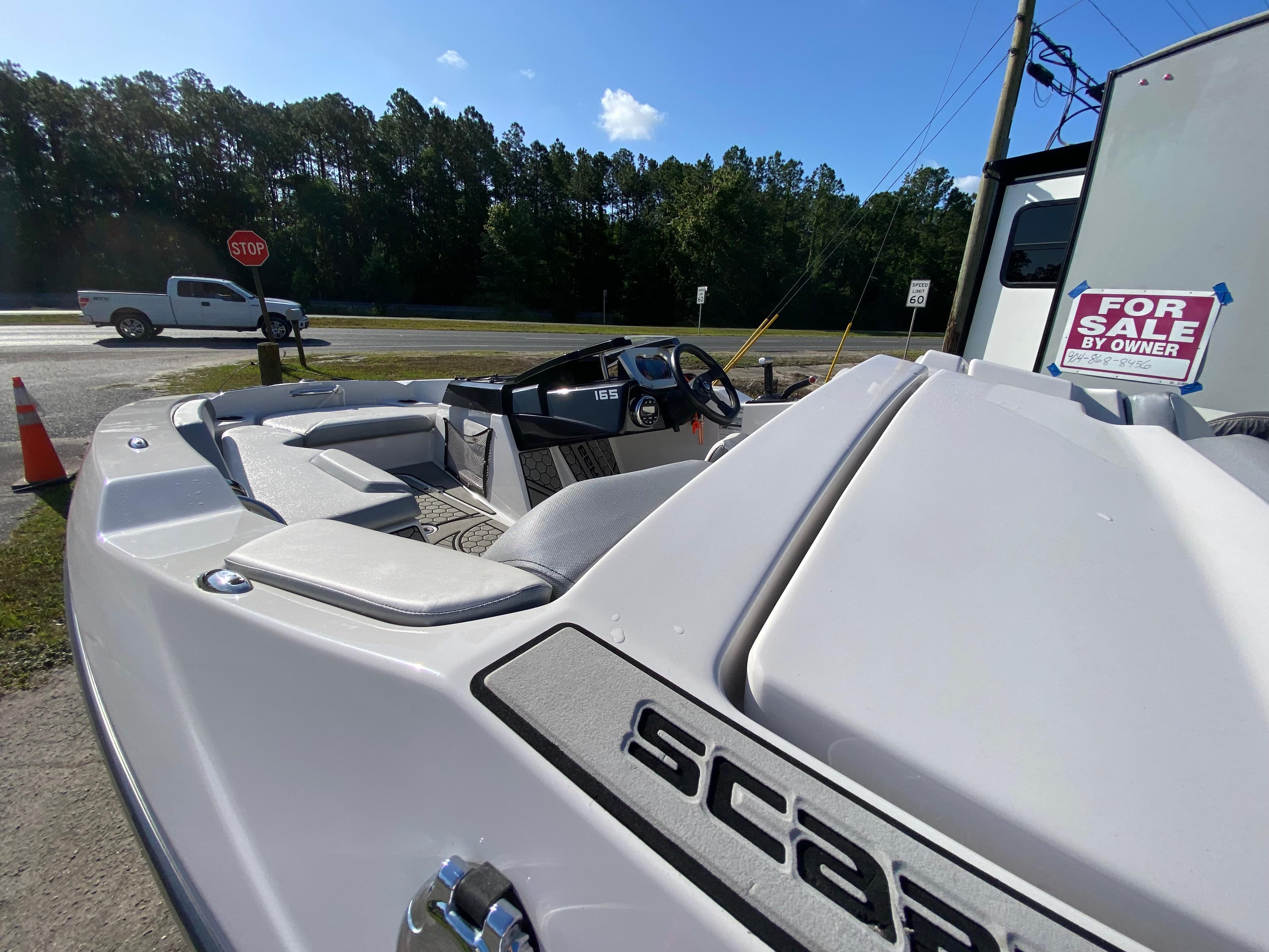 2018 Scarab 165 boat for sale, parked outdoors with a "For Sale by Owner" sign.