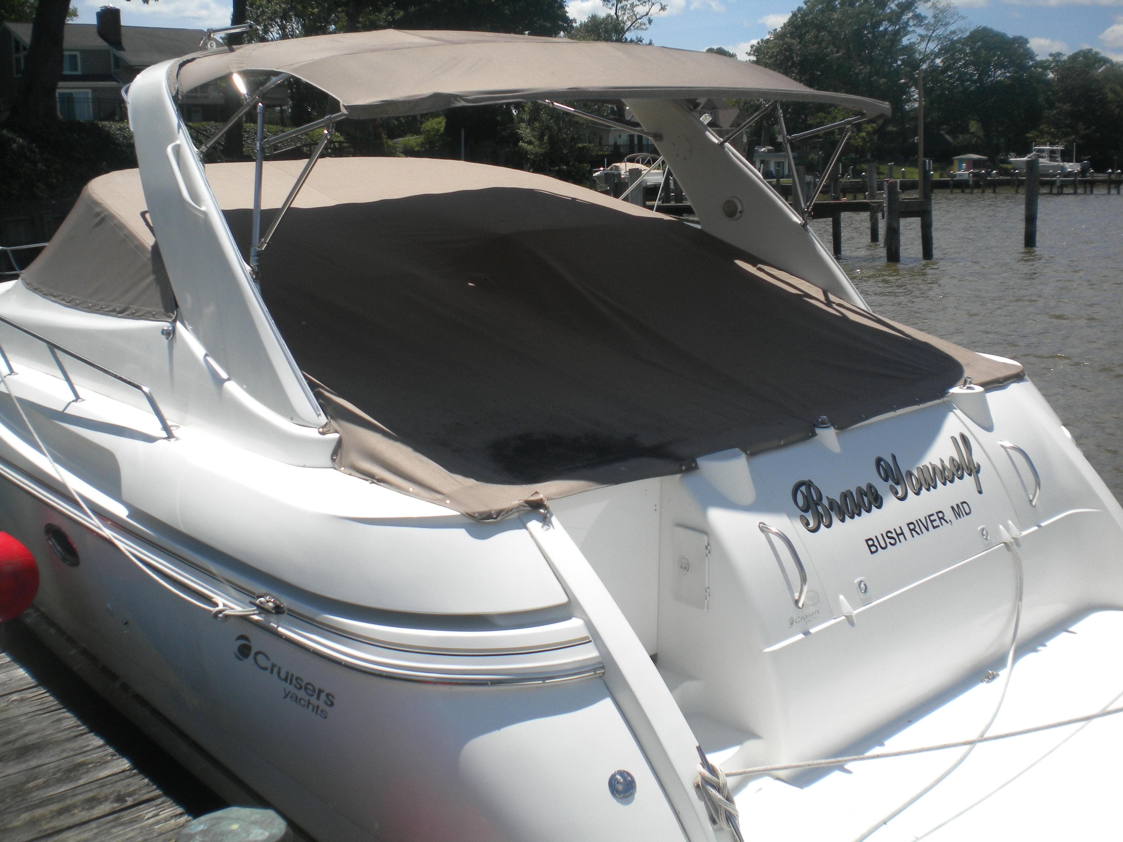 1998 Cruisers 3870 Express yacht docked, featuring a covered deck and sleek design.