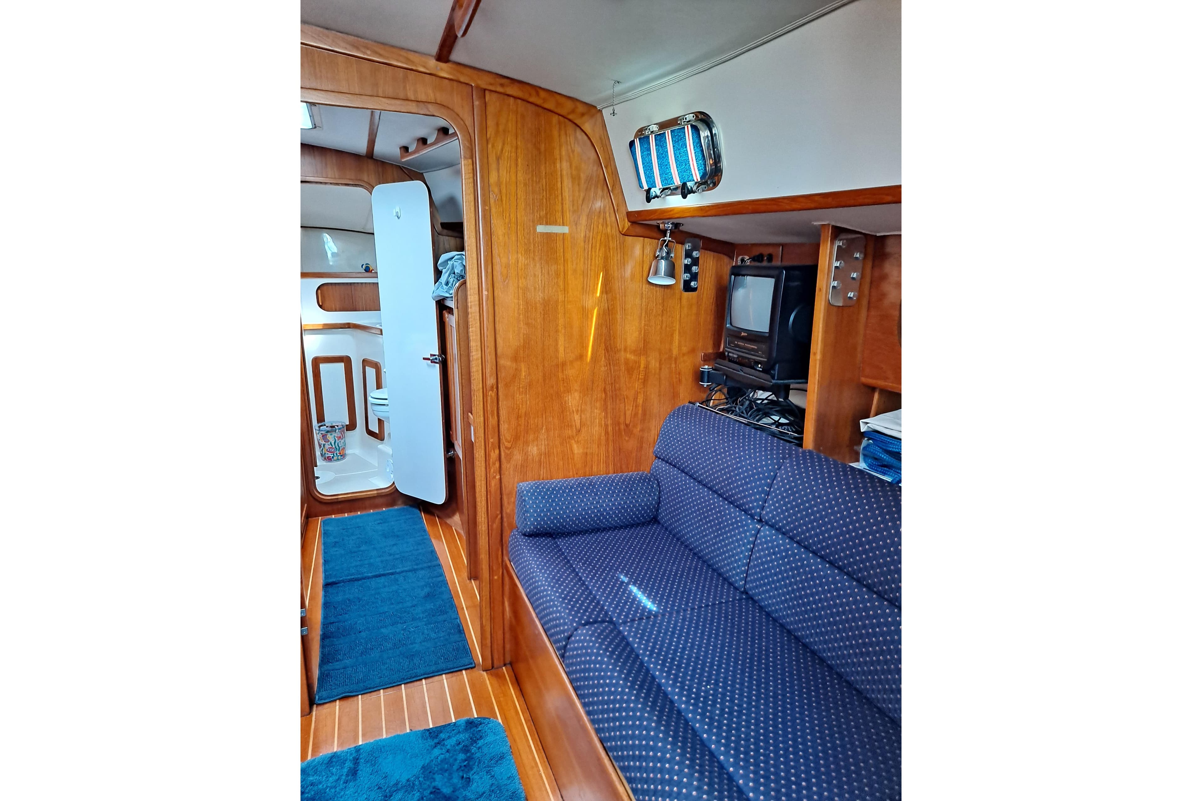 Interior of a 1998 Caliber 40LRC yacht with blue sofa and wooden paneling.