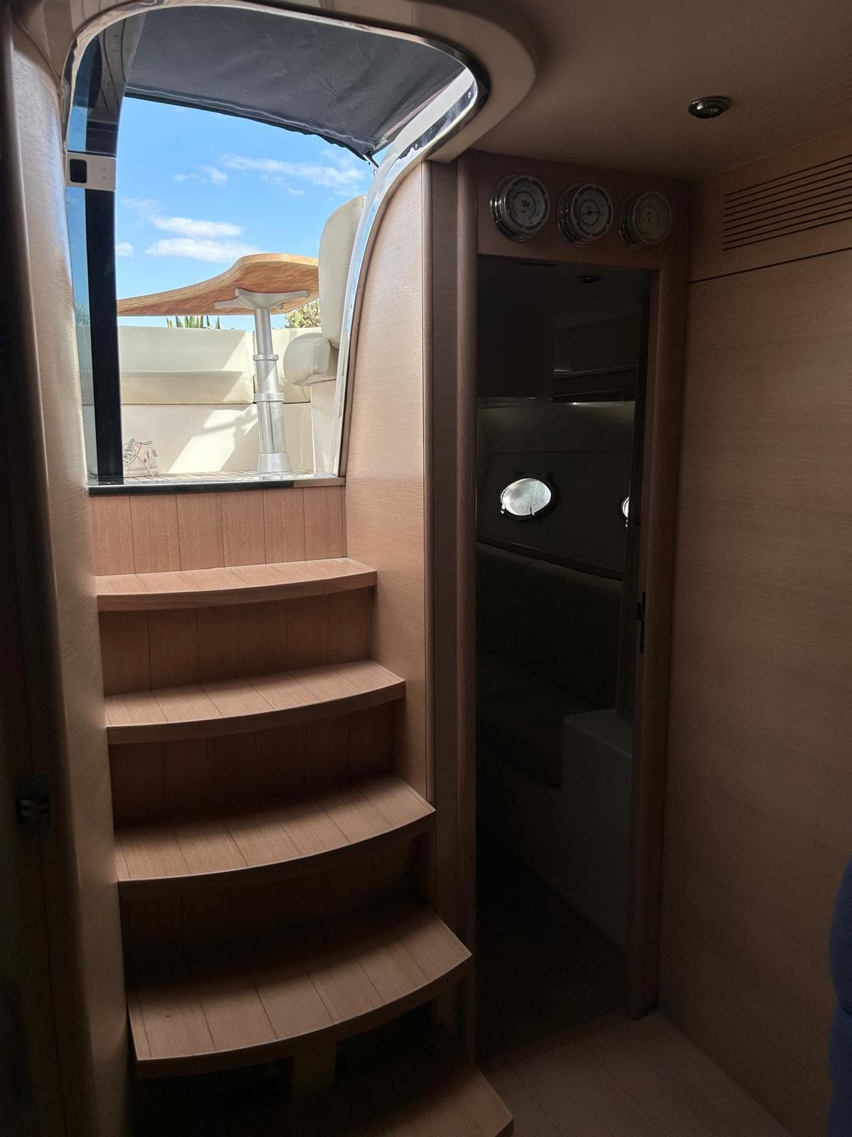 Interior view of 2010 Mig 43 yacht with wooden stairs and porthole windows.