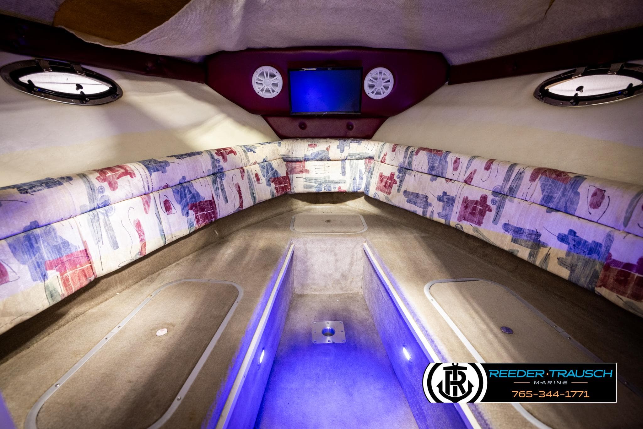 1999 Crownline 242 CR cabin interior with patterned seating and ambient lighting.