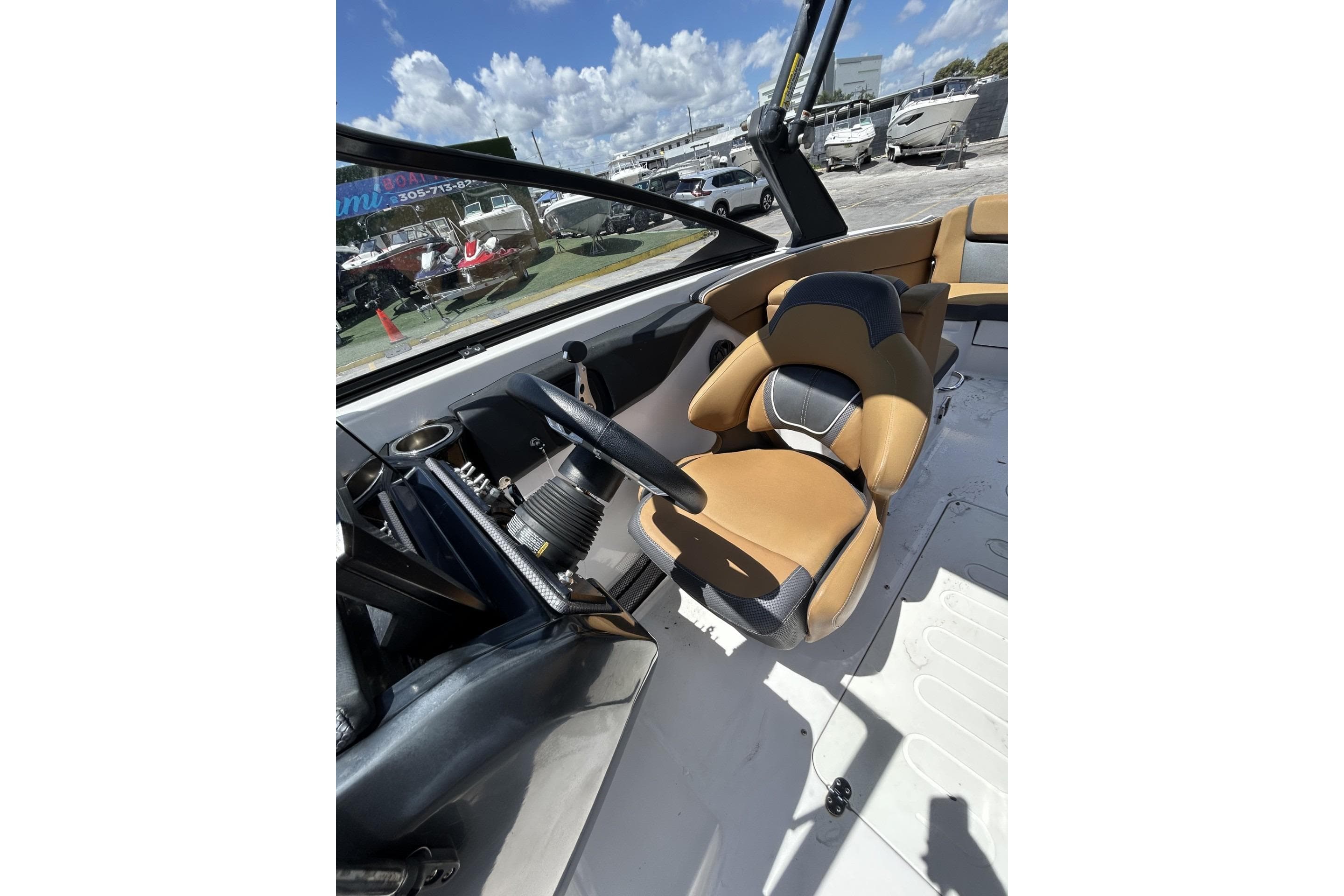 2019 Scarab 255 ID boat interior with tan and black seating, steering wheel, and dashboard.