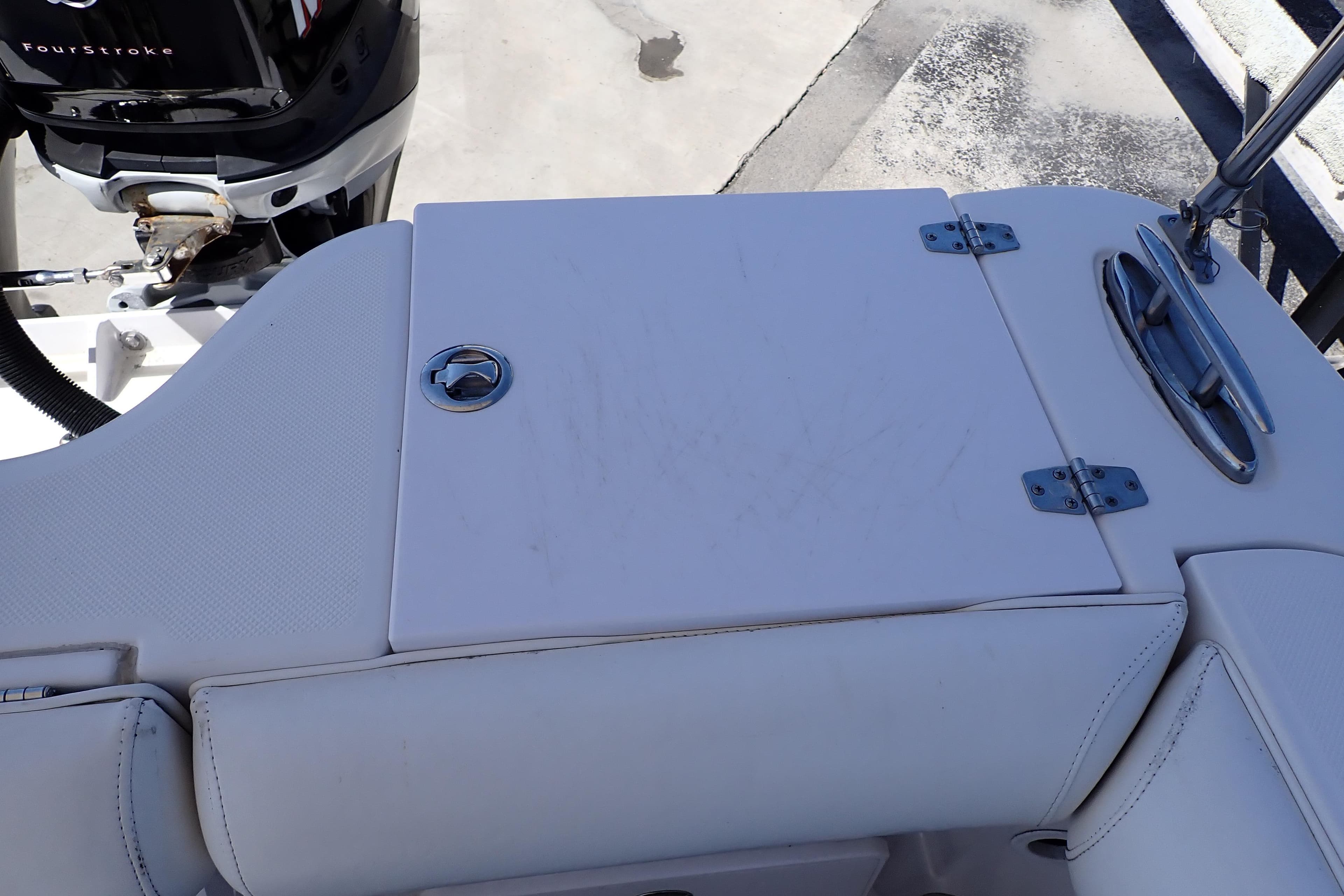 2014 Pro-Line 32 Express boat deck with storage compartment and outboard motor.