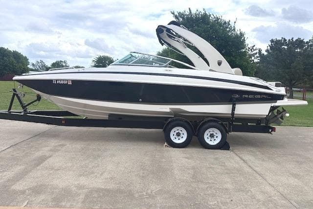 2014 Regal 27 FasDeck boat on trailer, parked outdoors on concrete surface.