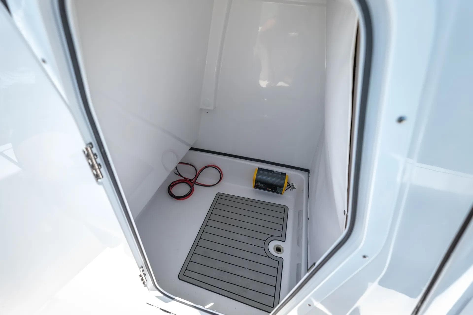 2026 Sportsman Masters 247 Bay Boat interior storage compartment with mat and cables.
