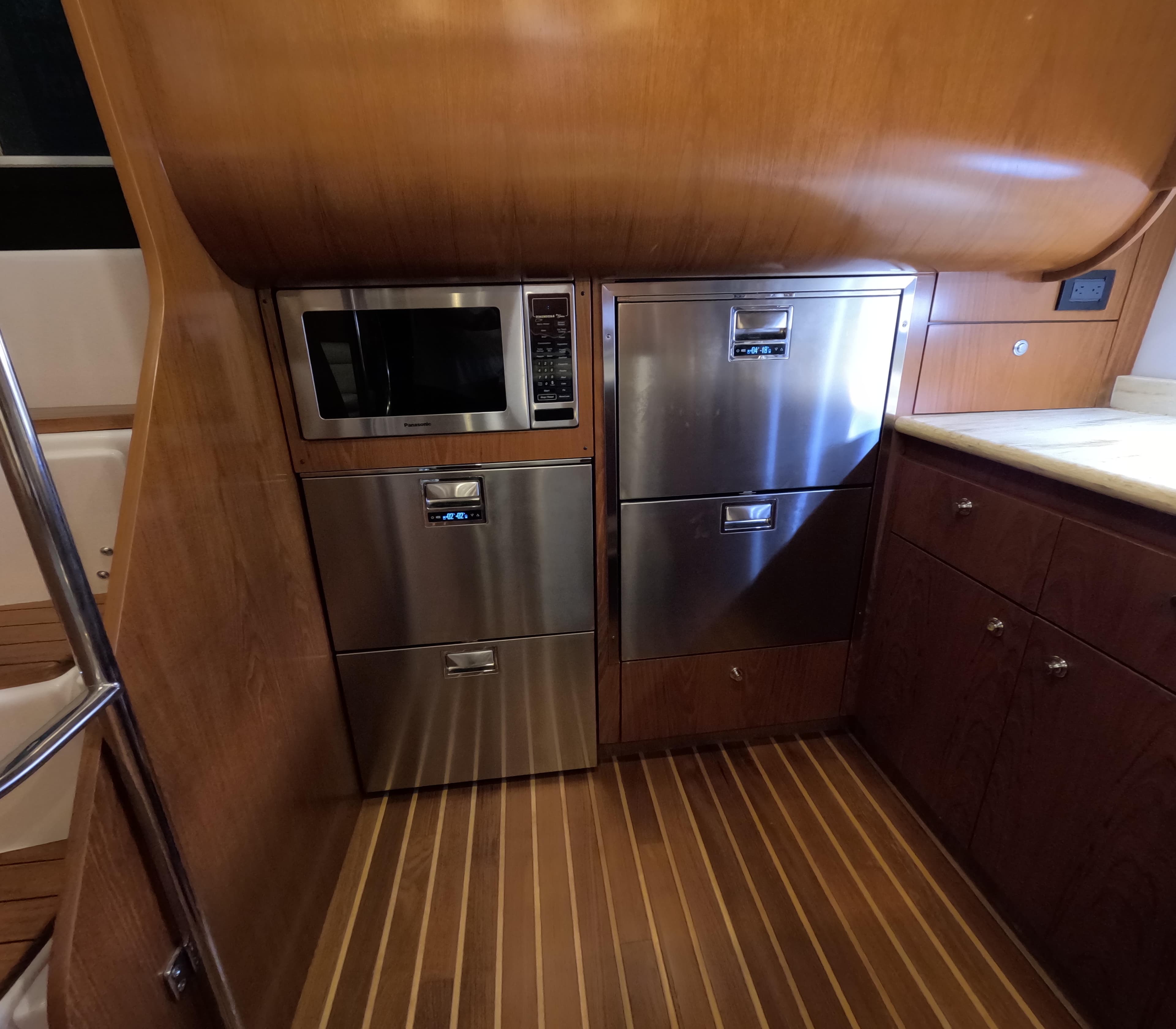 Tiara Yachts 2004 5200 Sovran Salon kitchen with stainless steel appliances and wooden cabinetry.