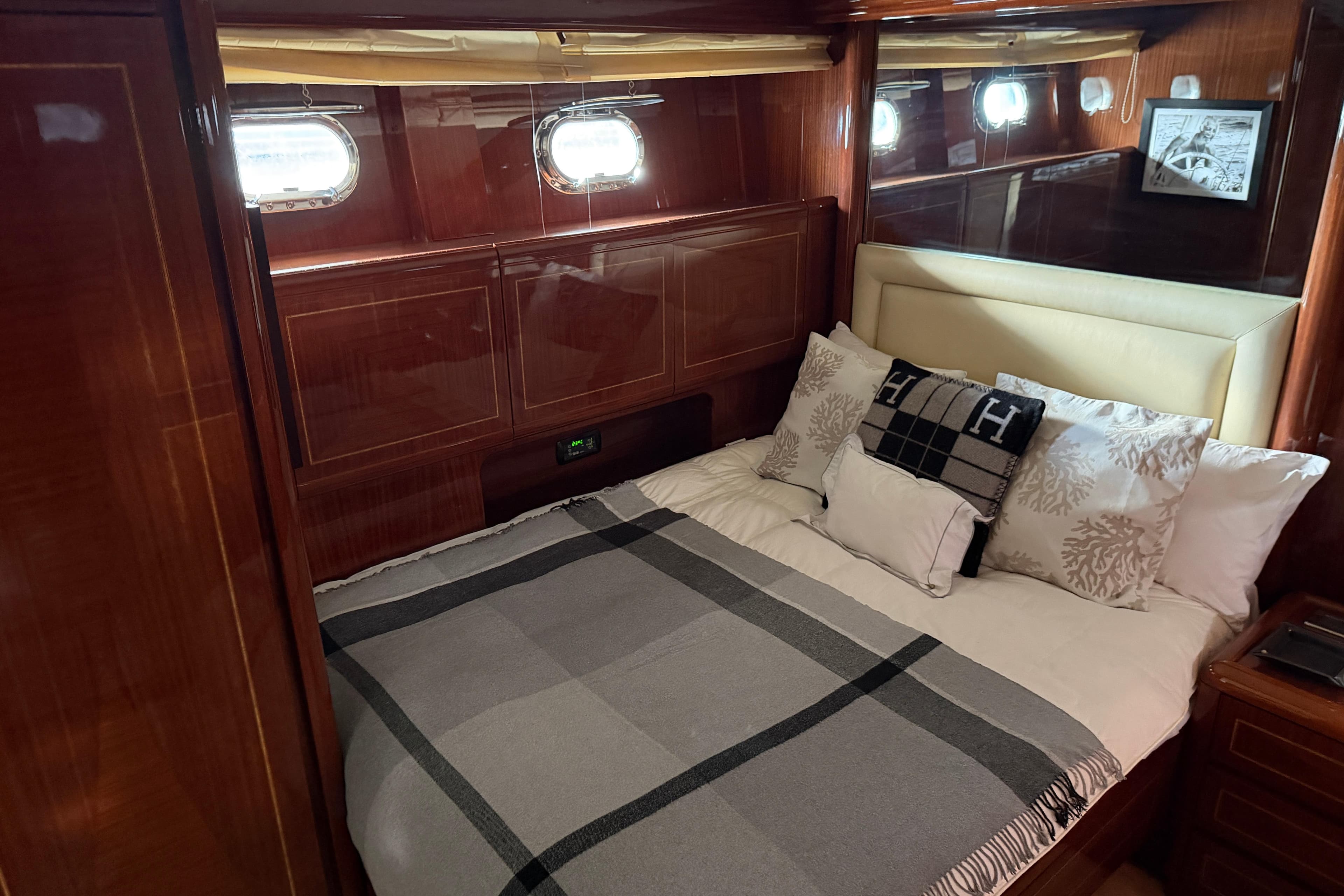 Luxurious cabin interior of 2004 Mangusta 72 yacht with elegant bedding and wood paneling.