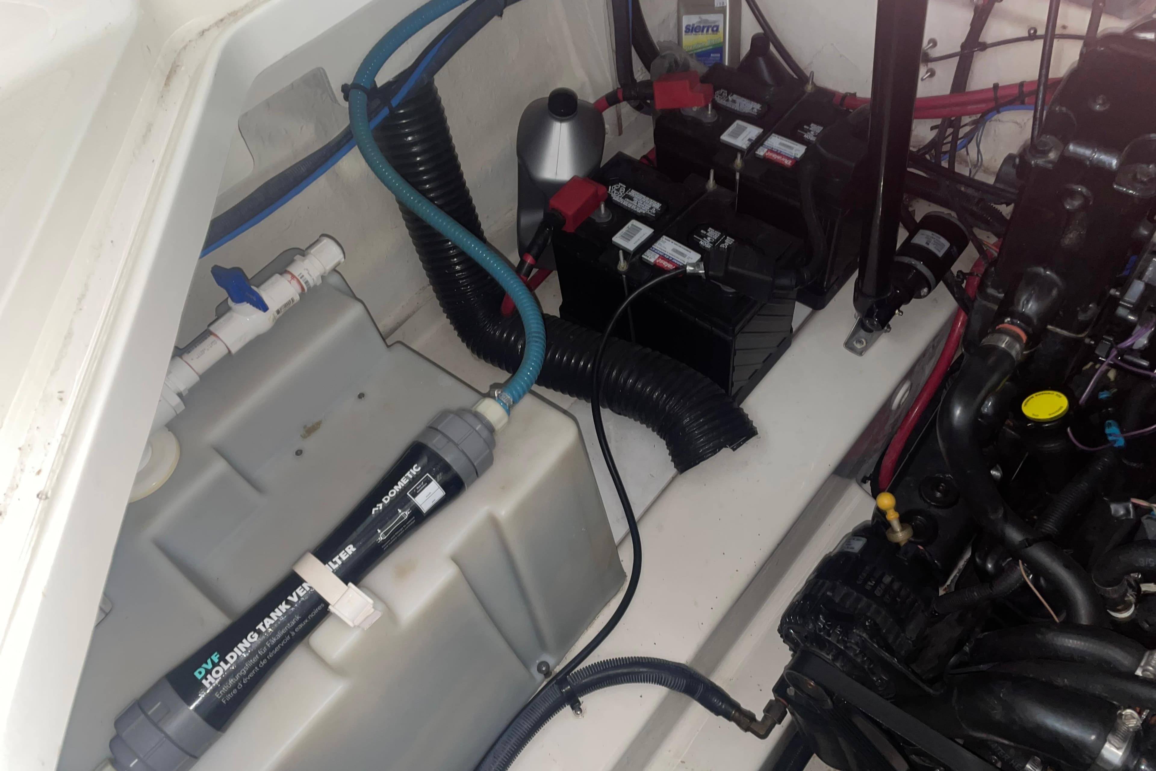 Engine compartment of a 2006 Sea Ray Sundancer 260, showing batteries and holding tank vent filter.