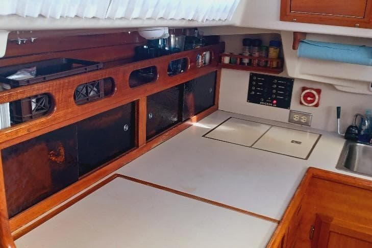 1973 Ericson 35 yacht interior kitchen with wooden cabinets and modern appliances.
