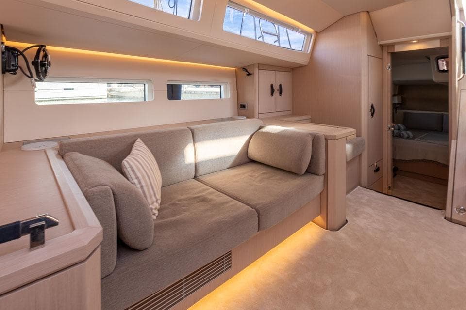 Luxurious interior of 2023 Jeanneau 60 yacht with modern seating and ambient lighting.