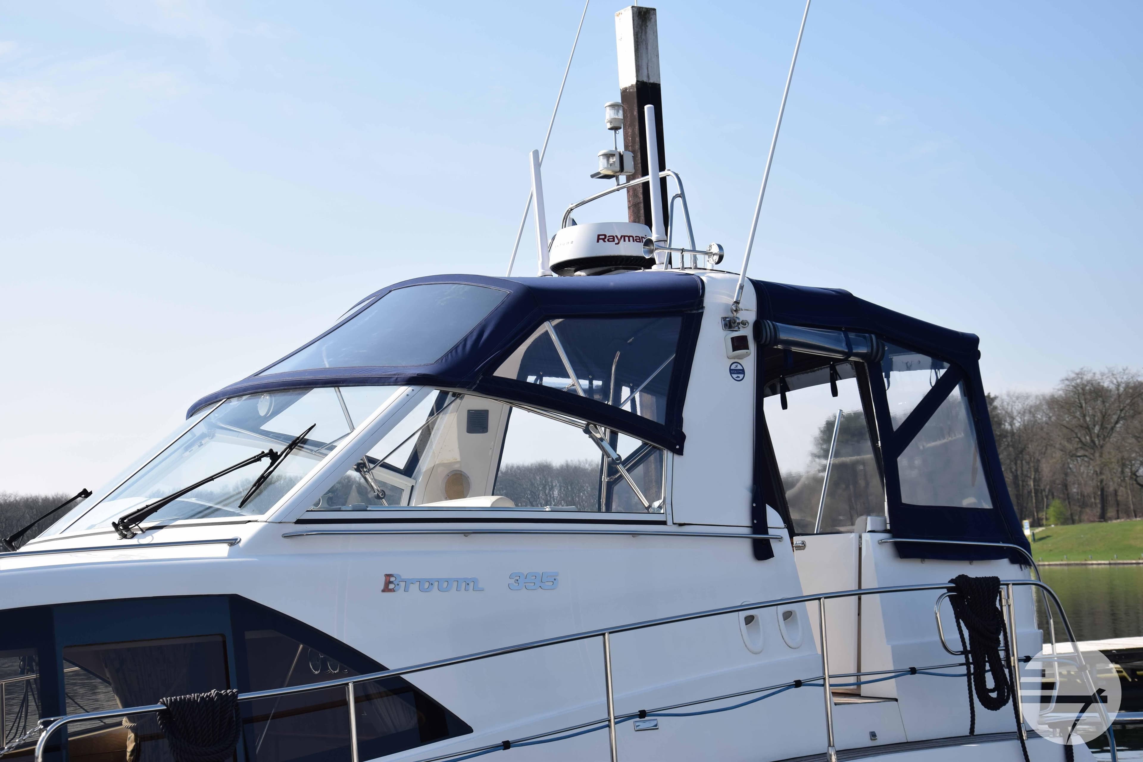 2010 Broom 395 boat with blue canopy, docked on a sunny day.