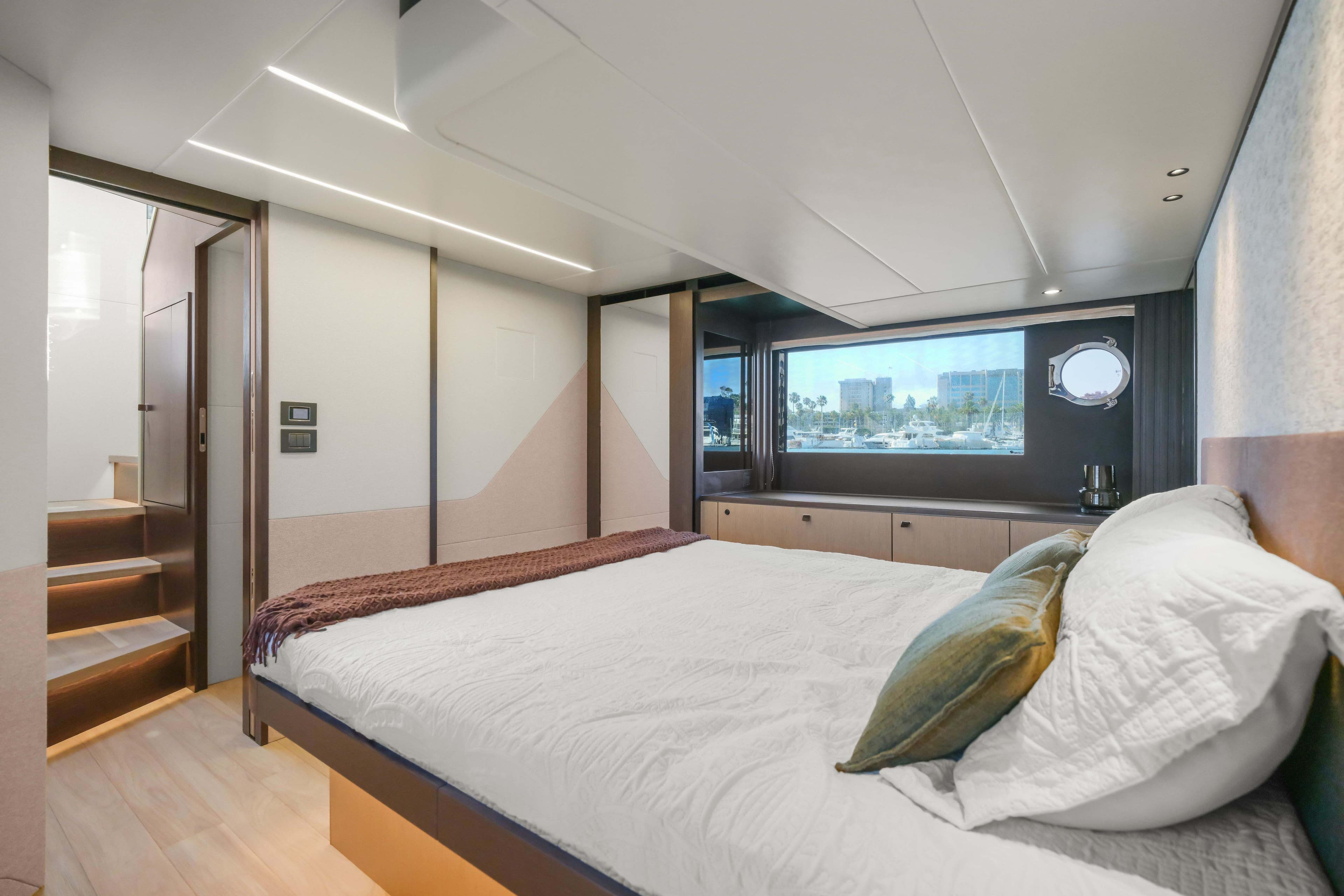 Luxurious bedroom interior of 2026 Absolute 52 Fly yacht with modern design and large window view.