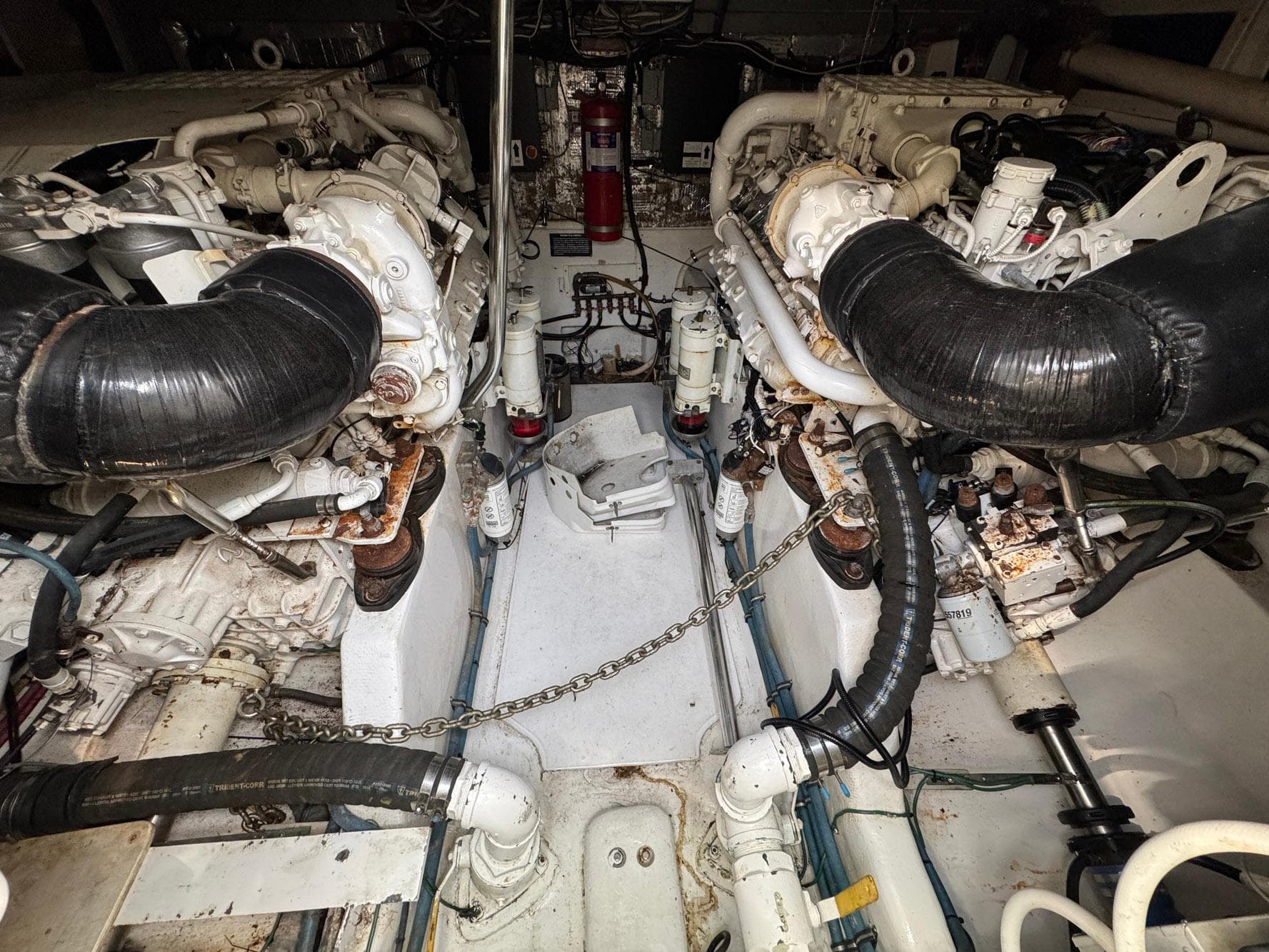 Engine room of a 1999 Cabo 45 Express boat, featuring dual engines and mechanical components.